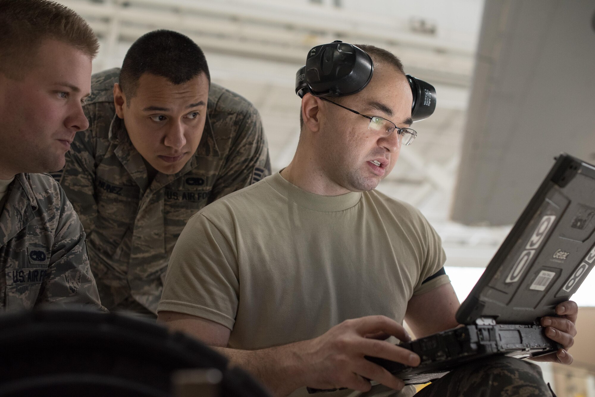 Senior Airman Brandon Mayfield (right), 945th Aircraft Maintenance Squadron crew chief, reviews a technical order for replacing C-17 Globemaster III engine panels, at Travis Air Force Base, Calif. Mayfield and Senior Airman Geoff Hayes (left), 945th AMXS guidance and control specialist, and Staff Sgt. Simon Nunez (center), 945th AMXS crew chief, worked together Feb. 10, 2017 during Wrench Week, which offers Citizen Airmen opportunities to reinforce and build their primary job skills. (U.S. Air Force photo by Ken Wright)