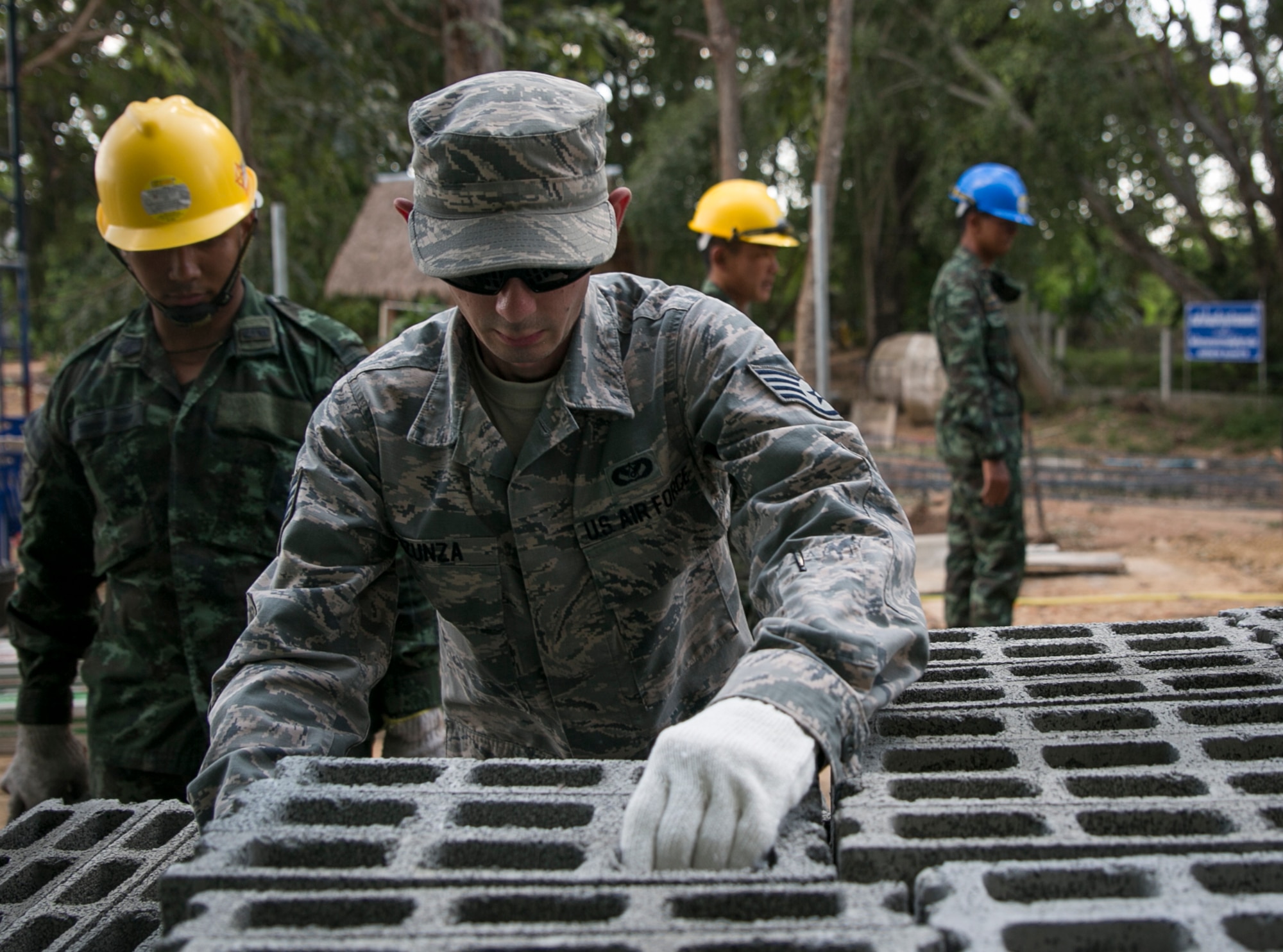 U.S. Air Force Staff Sgt. Daniel Inzunza, with the 35th Civil Engineering Squadron, moves cinder blocks with soldiers of the Royal Thai Army at Ban Non Lueam School in Korat Province, Thailand, Jan. 27, 2017. Inzunza, a native of San Jose, Calif., is a heavy construction supervisor while supporting COBRA GOLD 17 (CG17). In its 36th iteration, CG17 is the largest Theater Security Cooperation exercise in the Indo-Asia-Pacific region and is an integral part of the U.S. commitment to strengthen engagement in the region.  (U.S. Marine Corps photo by Sgt. Ally Beiswanger)