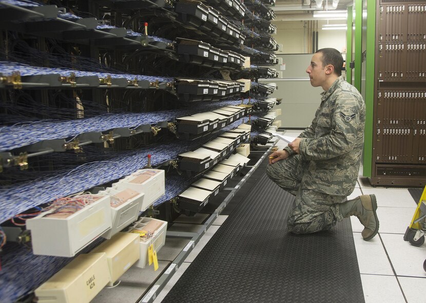 Airman 1st Class Kevin Kieser, 88th Communications Squadron Telephone Repair Shop voice network system technician, searches the main distribution frame looking for a specific phone line that is having issues, Jan. 27, 2017, at Wright-Patterson Air Force Base, Ohio. Each blue and white wire serves one of more than 20,000 Wright-Patterson telephone lines. (U.S. Air Force photo by R.J. Oriez/Released)