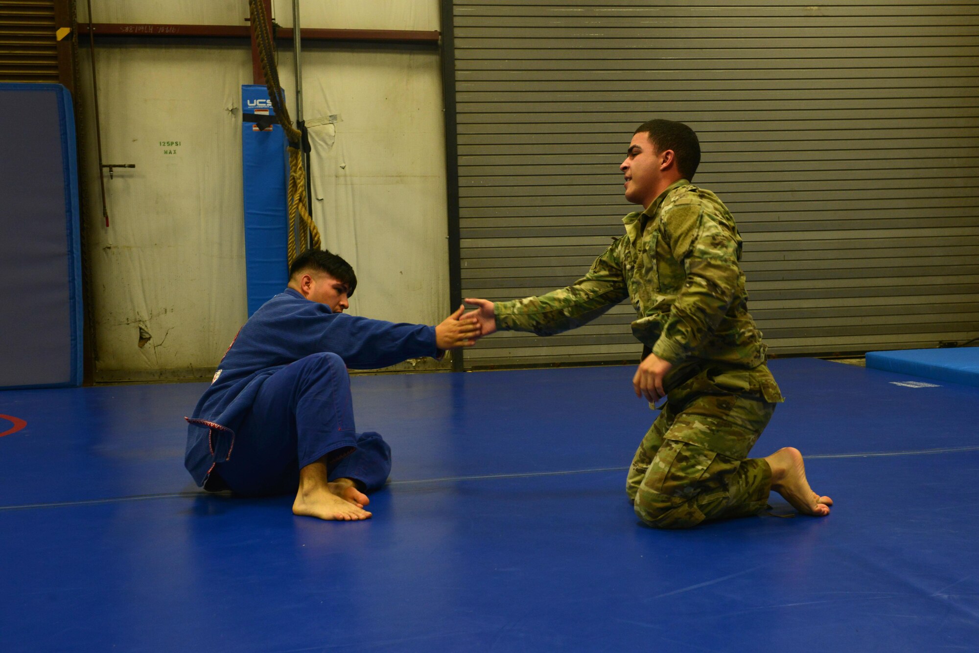 U.S. Army Staff Sgt. Joel Lung, U.S. Army Central battalion intelligence noncommissioned officer in charge, and Pfc. Melvyn Santos, U.S. ARCENT geospatial engineer, congratulate each other after a sparring match at Shaw Air Force Base, S.C., Feb. 7, 2017. Both Airmen and Soldiers can attend classes, including U.S. ARCENT combatives, at the Combative House. (U.S. Air Force photo by Airman 1st Class Destinee Sweeney)