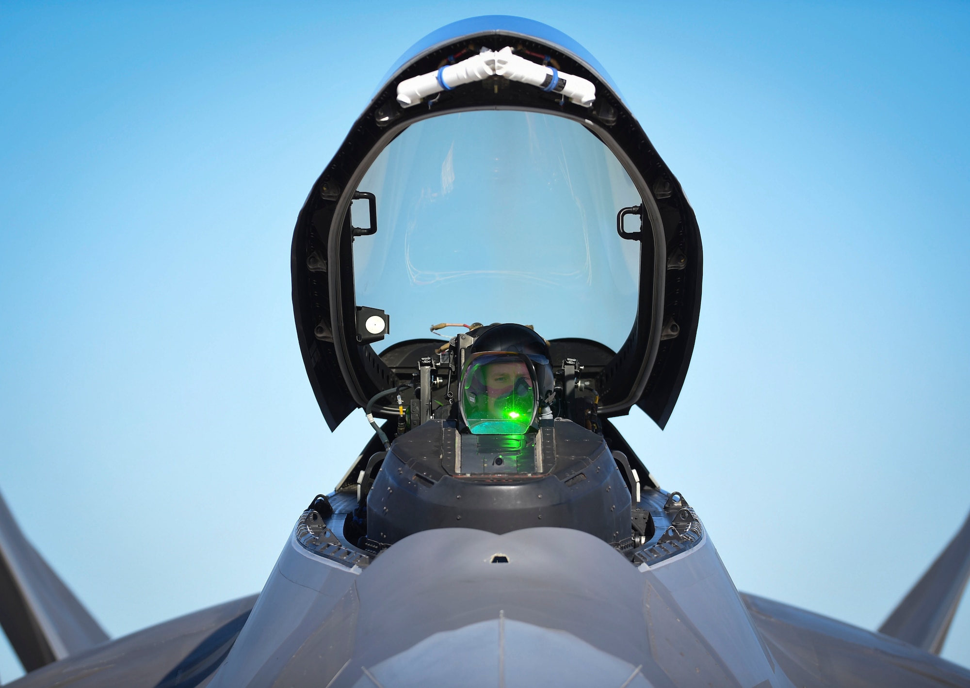 A 1st Fighter Wing F-22 Raptor pilot secures his helmet before takeoff during Red Flag 17-1 at Nellis Air Force Base, Nev., Jan 26, 2017. This is the first Red Flag in which Raptors are working alongside F-35A Lightning II’s to secure air dominance and provide cover for fourth generation assets. (U.S Air Force photo by Staff Sgt. Natasha Stannard)