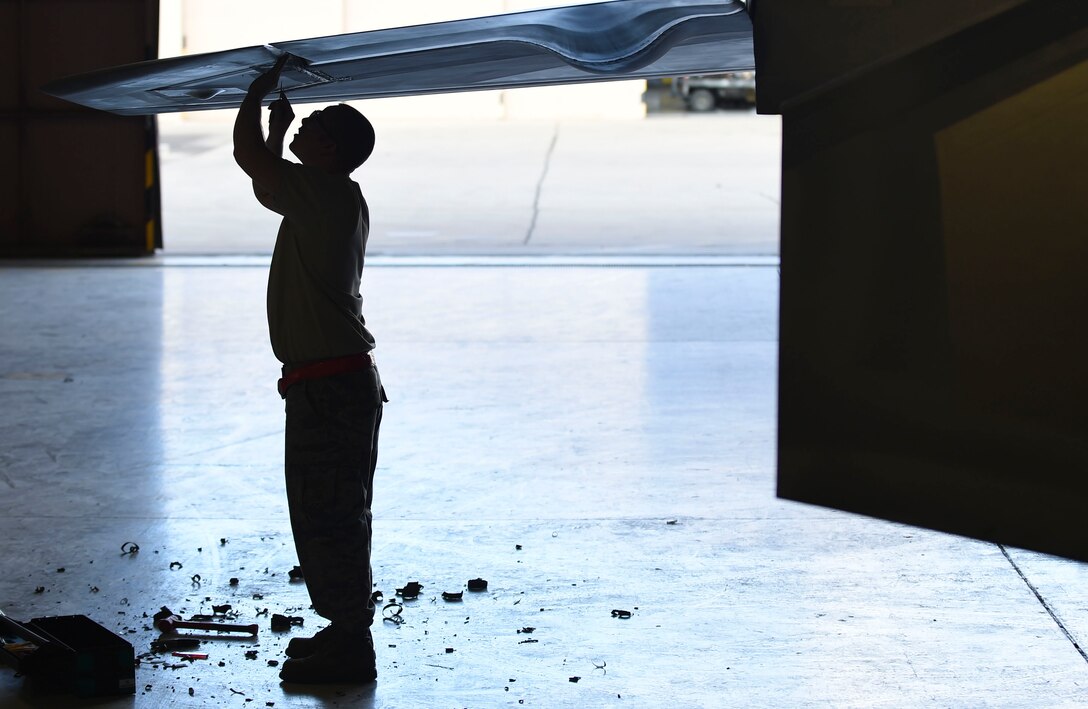 U.S. Air Force Staff Sgt. Zachary Dunn, 192nd Fighter Wing low observable aircraft structures technician, picks at radar absorbent material from an F-22 Raptor during Red Flag 17-1 at Nellis Air Force Base, Nev., Feb. 3, 2017. The absorbent material aids in the Raptor’s low observability, a factor that makes it a stealth fighter aircraft. (U.S. Air Force photo by Staff Sgt. Natasha Stannard)