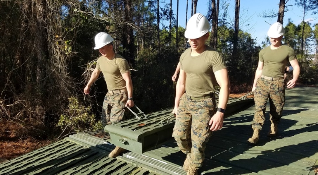 On February 8, 2017, Marines attached to Combat Engineer Officer course 2-17 (CEO 2-17) remove a ramp unit from a Medium Girder Bridge. During their period of instruction, CEO students learn how to plan for and construct a Medium Girder Bridge.  Pictured from left to right:  Second Lieutenants Carlos Perez, Manuel Ramirez, and Wesley Rathwick. 
