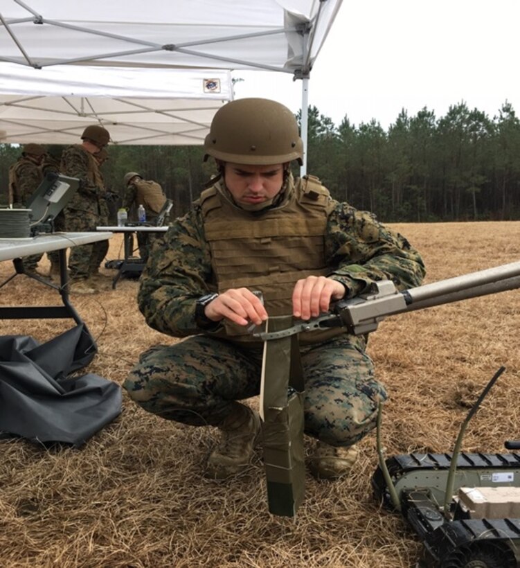 On February 3, 2017 Second Lieutenant Andrew Mullen, a Marine attending Combat Engineer Officer course 1-17 (CEO 1-17); places a four pound charge in the grippers of a robot and ensures that it is secure. The four blocks of C4 are taped together and a carrying handle is made with tape and a small stick so the robot has a steady grip on the explosive charge while carrying it down range to the explosive hazard.
