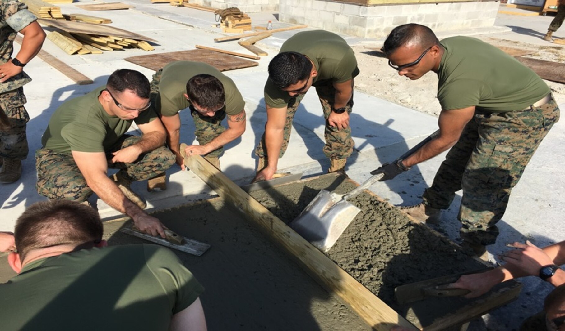 On October 28, 2016 Marines from Combat Engineer Officer course 1-17 (CEO 1-17) level and smooth out a concrete slab as they learn how to place and finish concrete. Pictured from left to right:  Second Lieutenants Andrew Mullen, Kameron Olsen, Salvador Guzman, and Aaron D’Silva.
