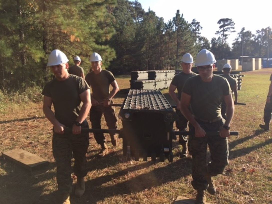 On November 16, 2016 Marines attached to Combat Engineer Officer course 1-17 (CEO1-17) use carrying bars to carry a top panel of a single story bridge. Medium Girder Bridges are built by connecting different pieces together while also slowly pushing the bridge across a gap. Pictured are Second Lieutenants Kristopher Satterwhite (Back Left), Taylor Hershberger (Back Right), Jacob Petersen (front left), and Oscar Machado (front right). 
