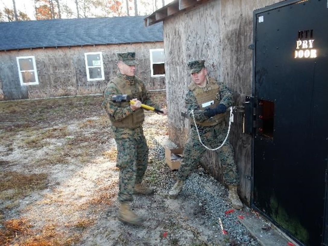 On December 15, 2016  Second Lieutenants Clark Kreitzer (left) and Taylor Hershberger (right), Marines attached to Combat Engineer Officer course 1-17 (CEO 1-17); practice mechanical breaching using a sledge hammer and hooligan tool to pry open a locked door. The hooligan tool is a multipurpose tool that is essential for mechanical breaching.
