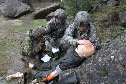 U.S. Army Sgt. Zachary Greene (center), Sgt. Juan Padilla (Right) and Spc. Keneesha Rogers (left) assess and treat a simulated casusalty during the 91st Training Division's Best Warrior Competition on February 7th, 2017 on Ft. Hunter Liggett, Calif. Soldiers were tested during many simulated missions to assess their proficiency in warrior tasks and battle drills. (U.S. Army photo by Spc. Derek Cummings/Released)