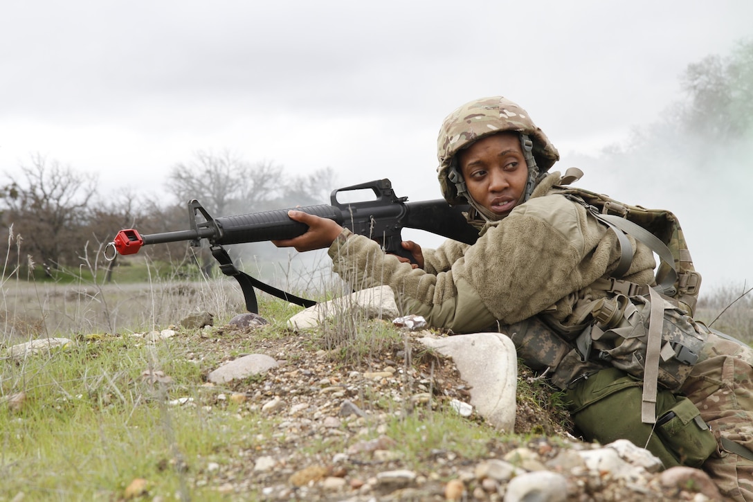 U.S. Army Spc. Keenesha Rogers of the 3-381st, 91st Training Division looks to a team member while pulling guard during a simulated extraction mission on February 8th, 2017 on Ft. Hunter Liggett, Calif. Soldiers competed in the 91st Training Division's Best Warrior Competition that tested their endurance and knowledge of warrior tasks and drills. (U.S. Army photo by Spc. Derek Cummings/Released)