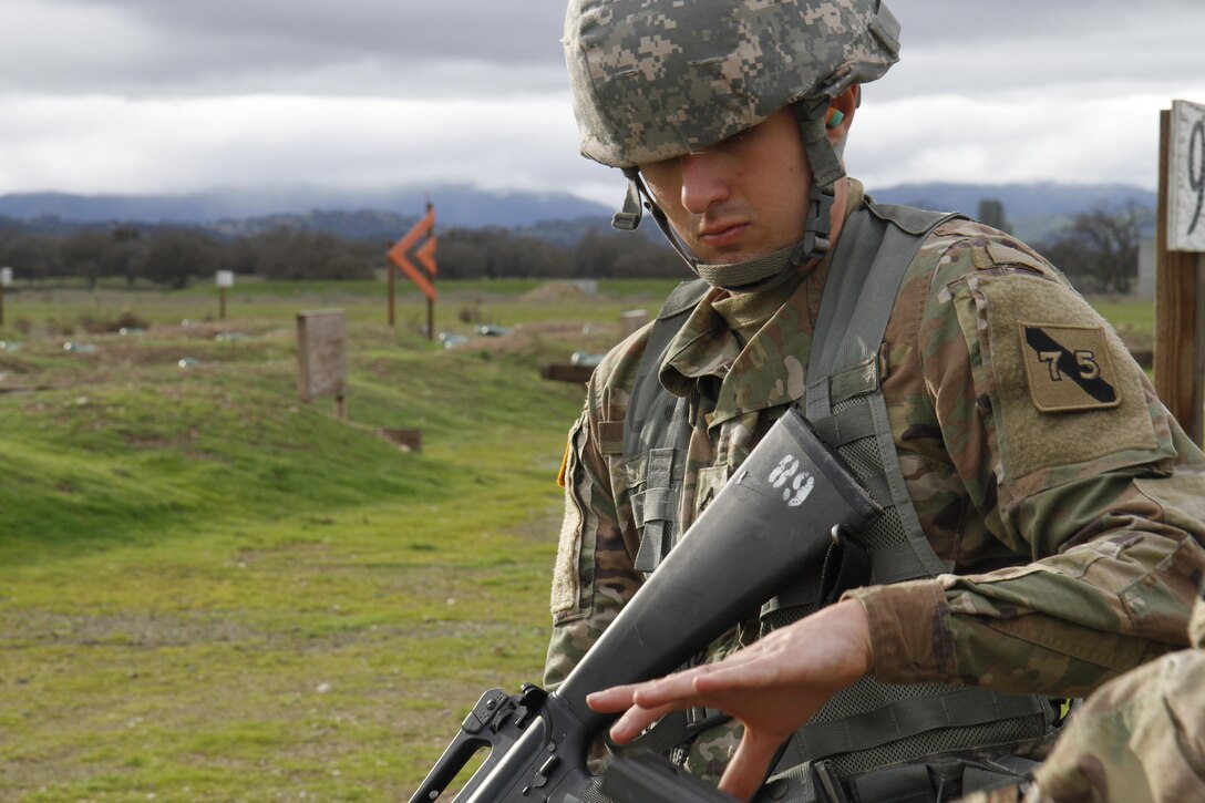 U.S. Army Pfc. Max Lanzing of the 75th Training Division recieves his rounds from a safety during a reactive fire lane on February 8th, 2017 on Ft. Hunter Liggett, Calif. Soldiers competed in the 91st Training Division's Best Warrior Competition that tested their endurance and knowledge of warrior tasks and drills. (U.S. Army photo by Spc. Derek Cummings/Released)