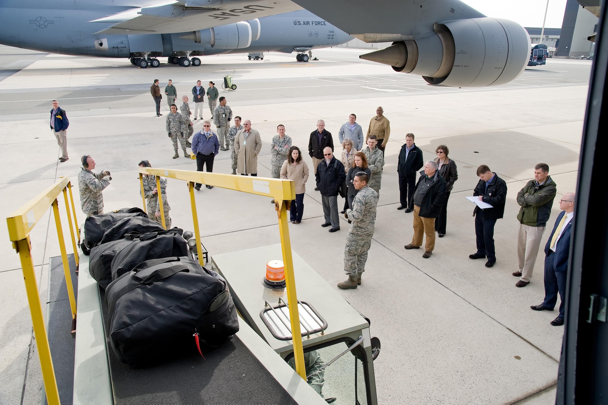 First Lt. Sylvester Fernandez de Castro, 436th Aerial Port Squadron flight commander of the Passenger Service Flight and Fleet Flight, along with fleet service personnel demonstrate the use of the baggage conveyor to load bags containing blankets, pillows and supplies onto a C-5M Super Galaxy Feb. 8, 2017, on Dover Air Force Base, Del. Members of Air Mobility Command’s “Aerial Port of the Future” study team from Scott Air Force Base, Ill., observed the loading of the bags through the “7 Left” troop door that are loaded when carrying passengers in the troop compartment. (U.S. Air Force photo by Roland Balik)