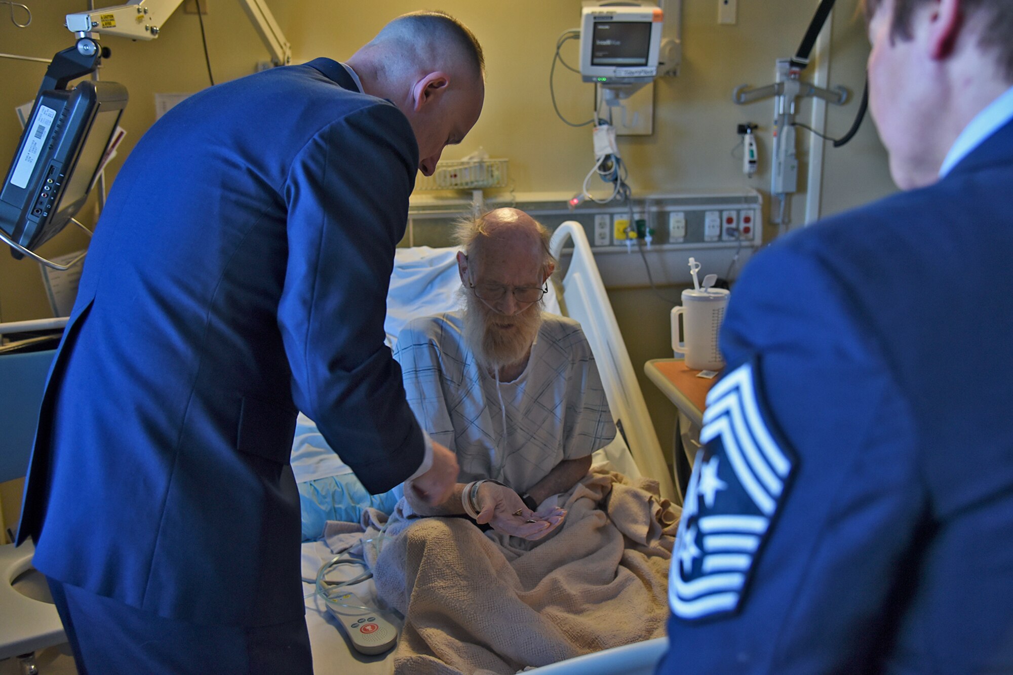 Col. Ryan Samuelson, 92nd Air Refueling Wing commander, presents a Fairchild Air Force Base pin and commemorative National Salute to Veteran Patients Week pin to Marine retired Maj. Robert Thompson Feb. 13, 2017, at Mann-Grandstaff VA Medical Center, Washington. National Salute to Veteran Patients Week is held the week of February 14 every year to say "thank you" to more than 98,000 veterans who are treated in Department of Veterans Affairs medical centers. (U.S. Air Force photo/Senior Airman Mackenzie Richardson)