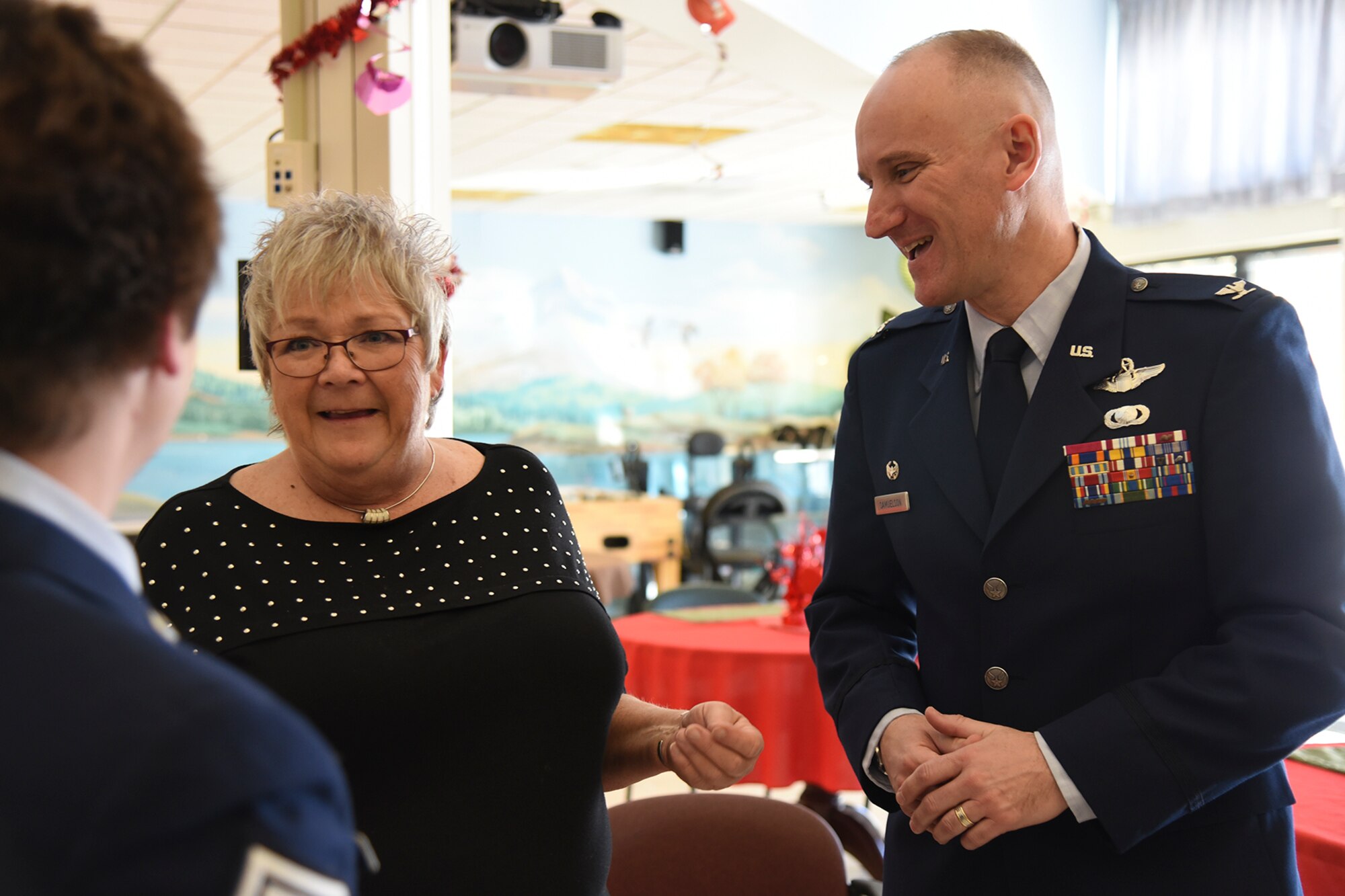 Debi Mouser, Mann-Grandstaff VA Medical Center recreation assistant and Navy veteran, talks about her love of caring for veterans with Col. Ryan Samuelson, 92nd Air Refueling Wing commander, and Chief Master Sgt. Shannon Rix, 92nd ARW command chief, Feb. 13, 2017, at Mann-Grandstaff VA Medical Center, Washington. Samuelson presented Mouser with a Fairchild Air Force Base pin for her service. (U.S. Air Force photo/Senior Airman Mackenzie Richardson)