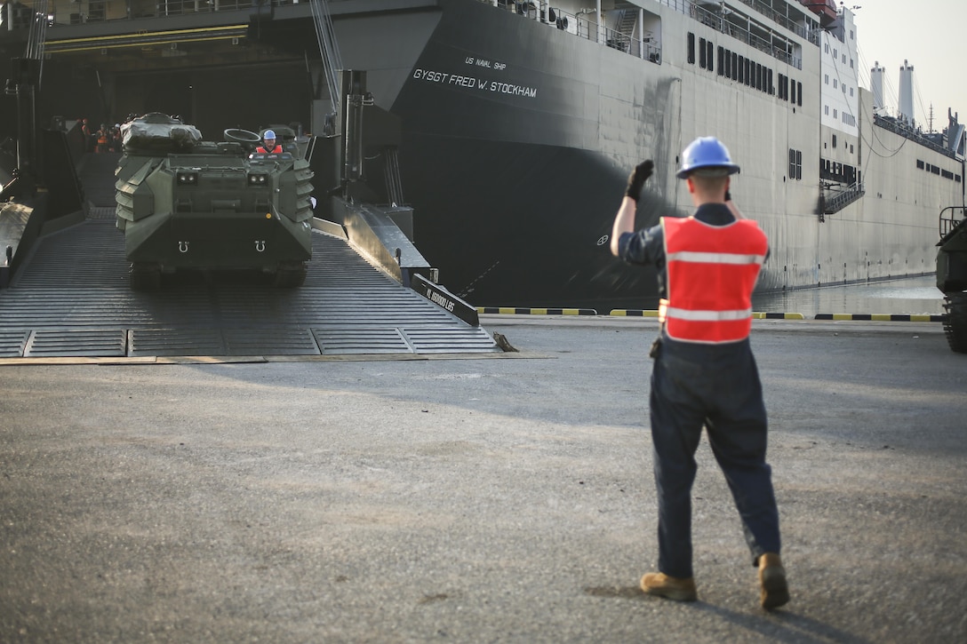 A U.S. Marine with Combat Logistics Battalion 4, guides an Assault Amphibious Vehicle from the USNS Fred W. Stockham, during exercise Cobra Gold, at Laem Chabang International Terminal, Thailand, Feb. 11, 2017. Cobra Gold, in its 36th iteration, is an important element of the United States' and all other participating nations' regional military to military engagement efforts. (U.S. Marine Corps photo by Cpl. Wesley Timm)