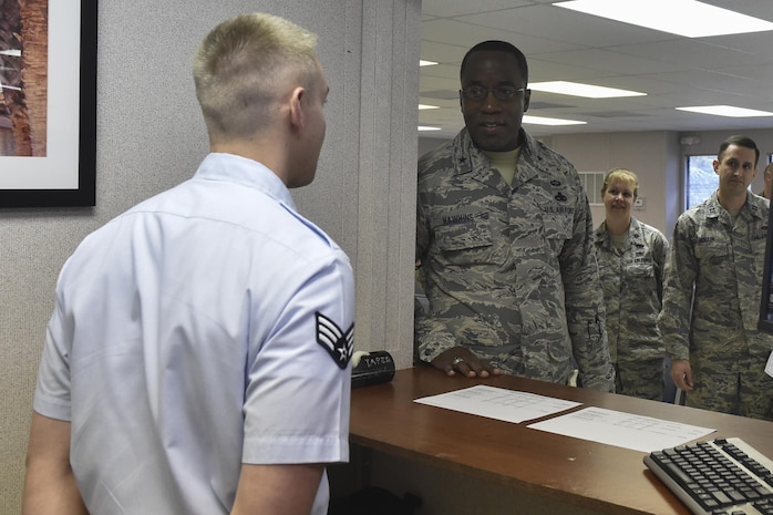 U.S. Air Force Brig. Gen. Stacey T. Hawkins, center, Air Mobility Command Logistics, Engineering and Force Protection director, talks with Senior Airman Alex Corbett, left, 437th Aerial Port Squadron passenger services technician, at the temporary passenger terminal on Feb. 9, 2017, at Joint Base Charleston, South Carolina. Hawkins visited multiple facilities on JB Charleston during his visit to meet with Airmen and senior leaders to discuss operations.