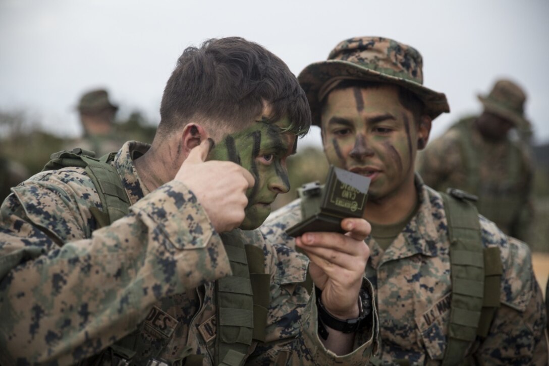 Lance Cpl. Lane Fernandes, left, and Cpl. Fransico Hernandez, infantrymen with Fox Company, Battalion Landing Team, 2nd Battalion, 5th Marines, 31st Marine Expeditionary Unit, apply camouflage face paint in preparation for a patrol exercise at the Jungle Warfare Training Center, Camp Gonsalves, Okinawa, Japan, Jan. 25, 2017. JWTC exposes Marines to training situations and environments unique to the Indo-Asia-Pacific region which sustain operational readiness and enhance forward deployed capabilities. As the Marine Corps’ only continuously forward deployed unit, the 31st Marine Expeditionary Unit’s air-ground-logistics team provides a flexible force, ready to perform a wide range of military operations, from limited combat to humanitarian assistance operations, throughout the Indo-Asia- Pacific region. (U.S. Marine Corp's photo by Lance Cpl. Breanna L. Weisenberger/Released) 