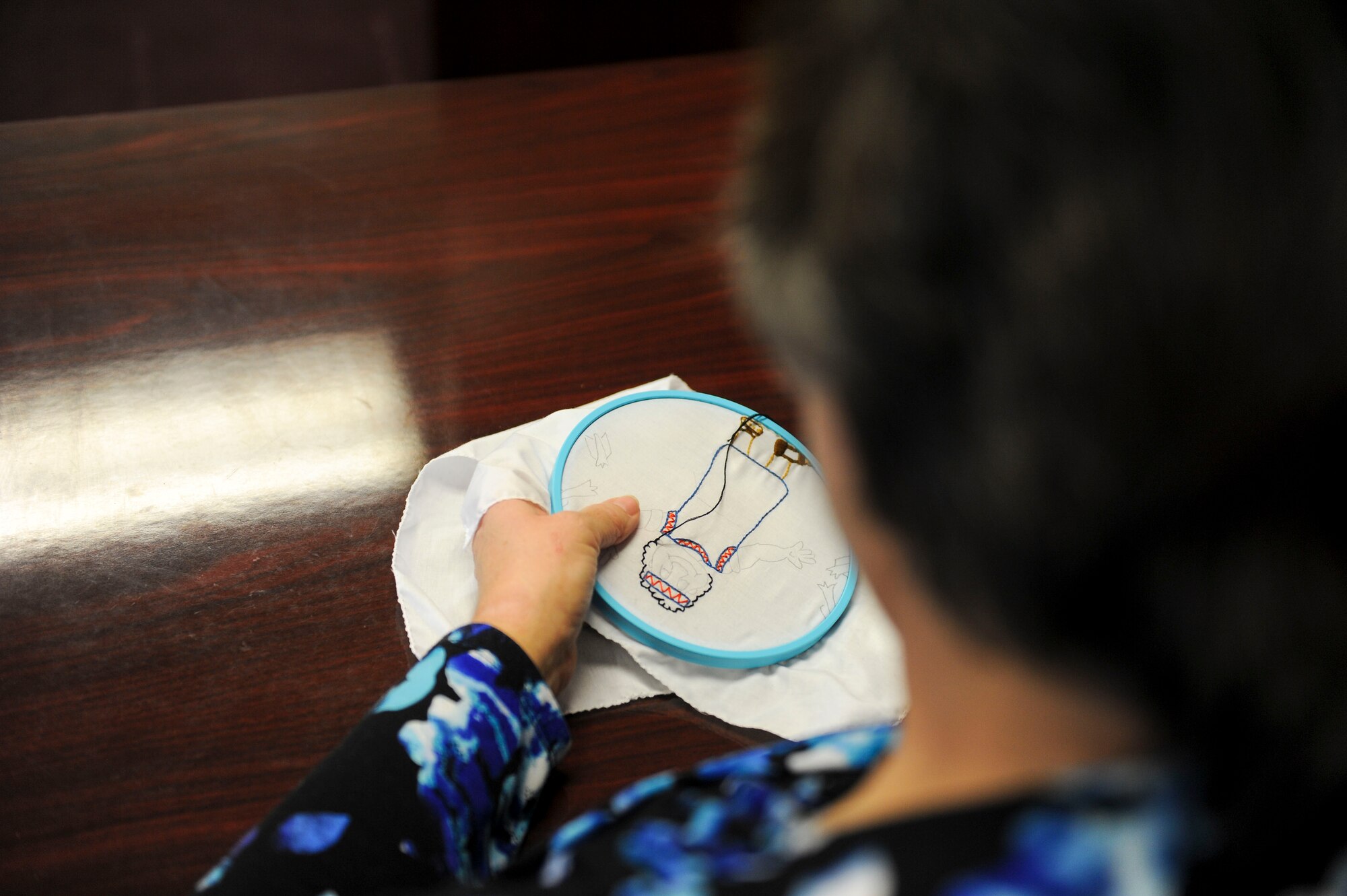 Department of the Air Force employee Kristina Anderson, a 354th Fighter Wing legal office receptionist secretary, embroiders a piece of a quilt Jan. 27, 2017, at Eielson Air Force Base, Alaska. Anderson has been sewing for approximately 45 years and usually spends her lunch breaks sewing gifts for her grandchildren. (U.S. Air Force photo by Airman Isaac Johnson)