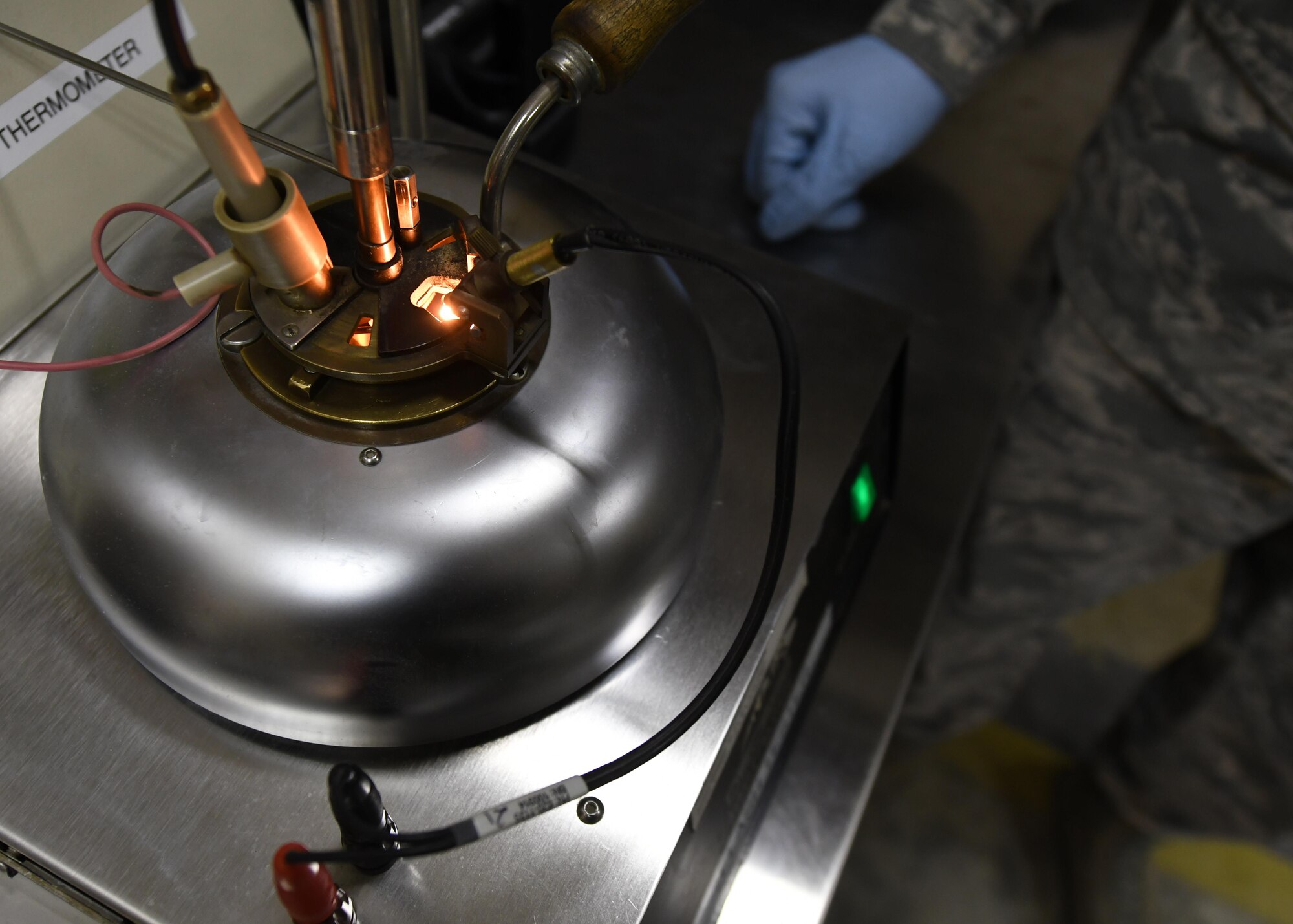 U.S. Air Force Staff Sgt. Mario Shanks, fuels laboratory NCO in charge with the 379th Expeditionary Logistics Readiness Squadron, stands by as a flash point tester checks a sample of fuel at Al Udeid Air Base, Qatar, Feb. 14, 2017. Checking the flash point helps determine what temperature the fuel burns at, and the type of fuel it is. (U.S. Air Force photo by Senior Airman Miles Wilson)