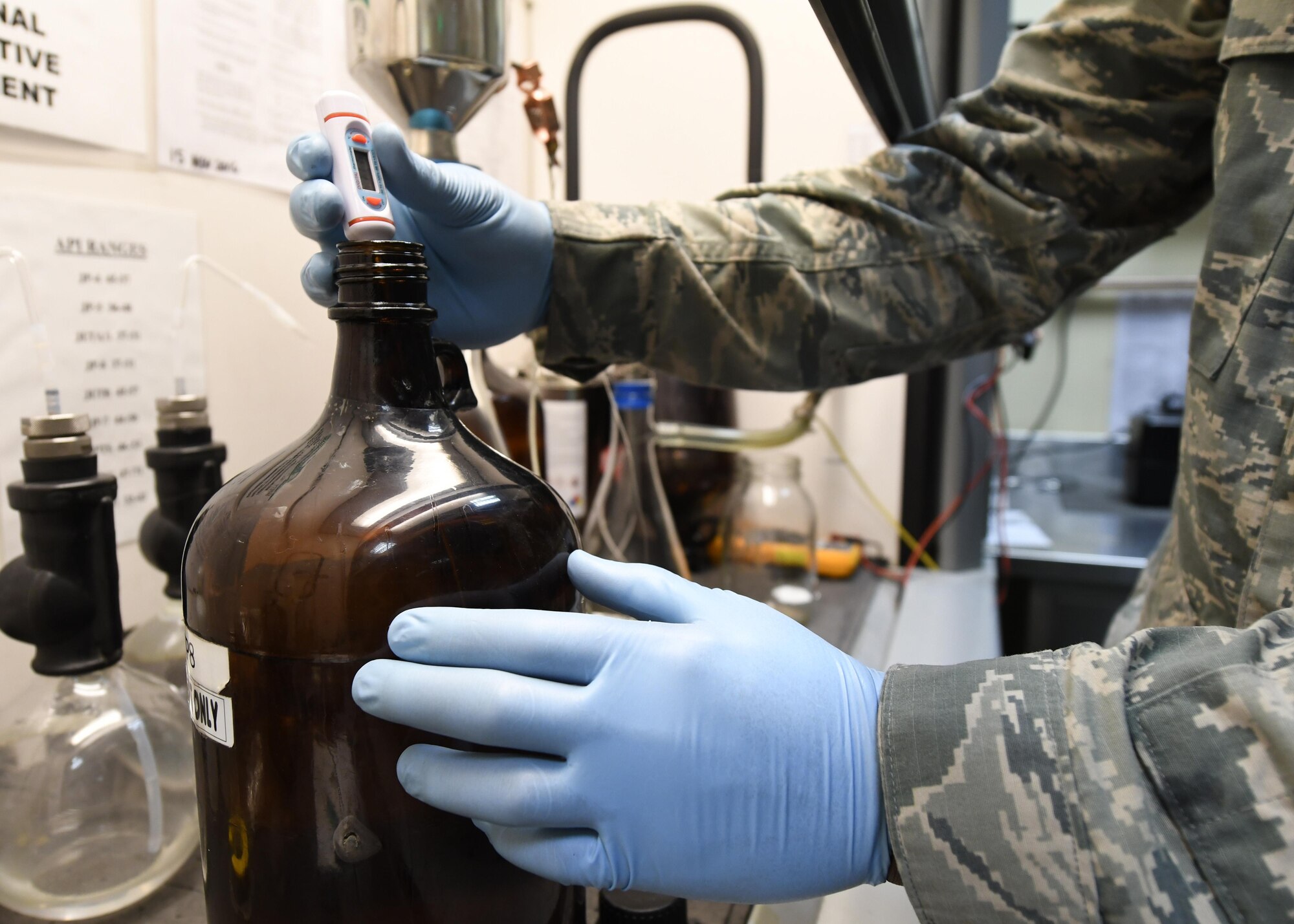 U.S. Air Force Airman 1st Class Jamar Gresham, a fuels apprentice with the 379th Expeditionary Logistics Readiness Squadron Fuels Laboratory, determines the temperature of a bottle of fuel at Al Udeid Air Base, Qatar, Feb. 14, 2017. In order to perform a bottle method test on fuel, it must first be brought to a temperature between 64-86 degrees Fahrenheit. (U.S. Air Force photo by Senior Airman Miles Wilson)