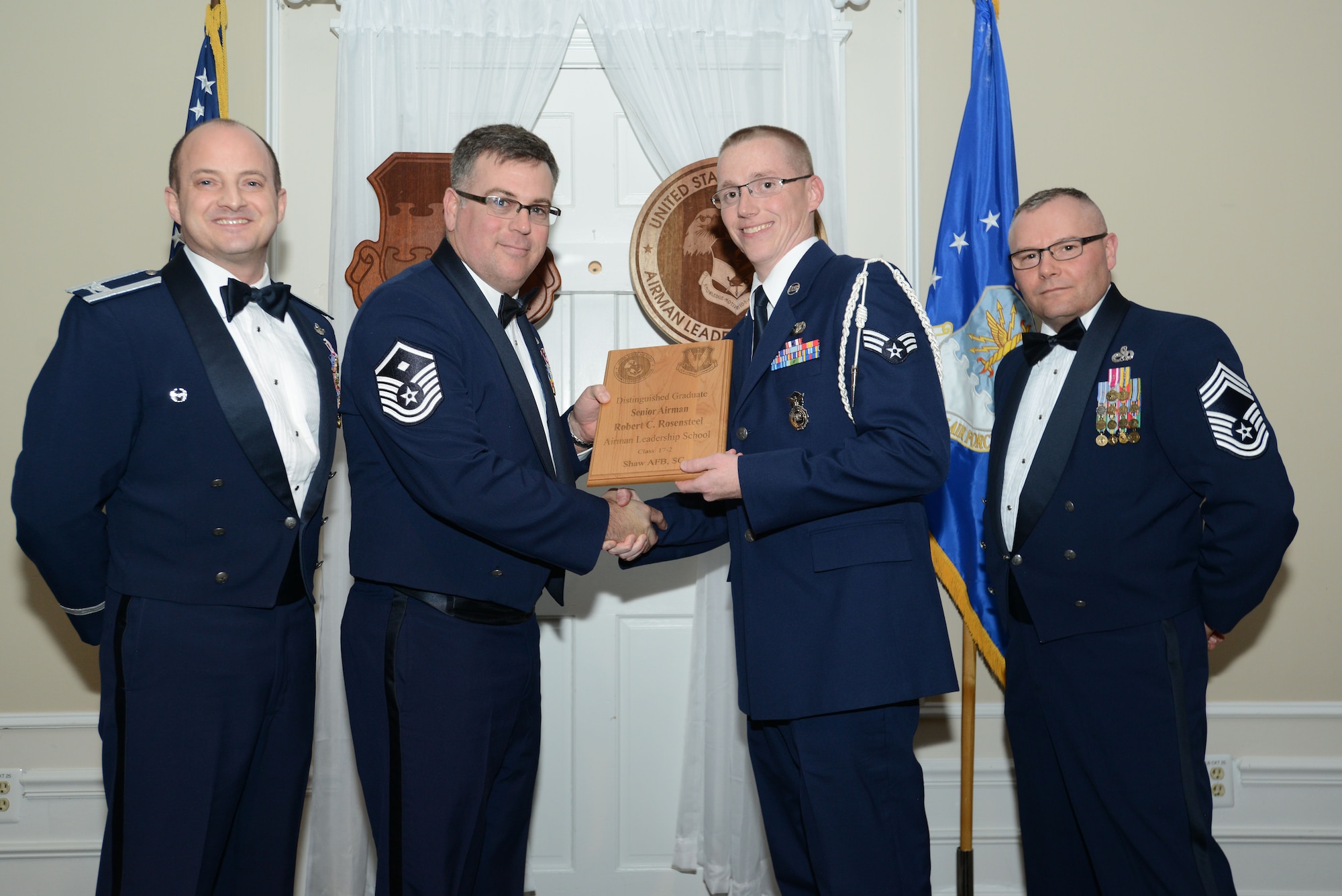 U.S. Air Force Senior Airman Robert Rosensteel, 20th Security Forces Squadron, receives a distinguished graduate award for the Senior Master Sgt. David B. Reid Airman Leadership School Class 17-2 from Master Sgt. Aaron Bunyea, 609th Air Communications Squadron first sergeant, at Shaw Air Force Base, S.C., Feb. 9, 2017. The distinguished graduate awards are given to the top 10 percent of the class for total point accumulation. (U.S. Air Force photo by Airman 1st Class Kelsey Tucker)