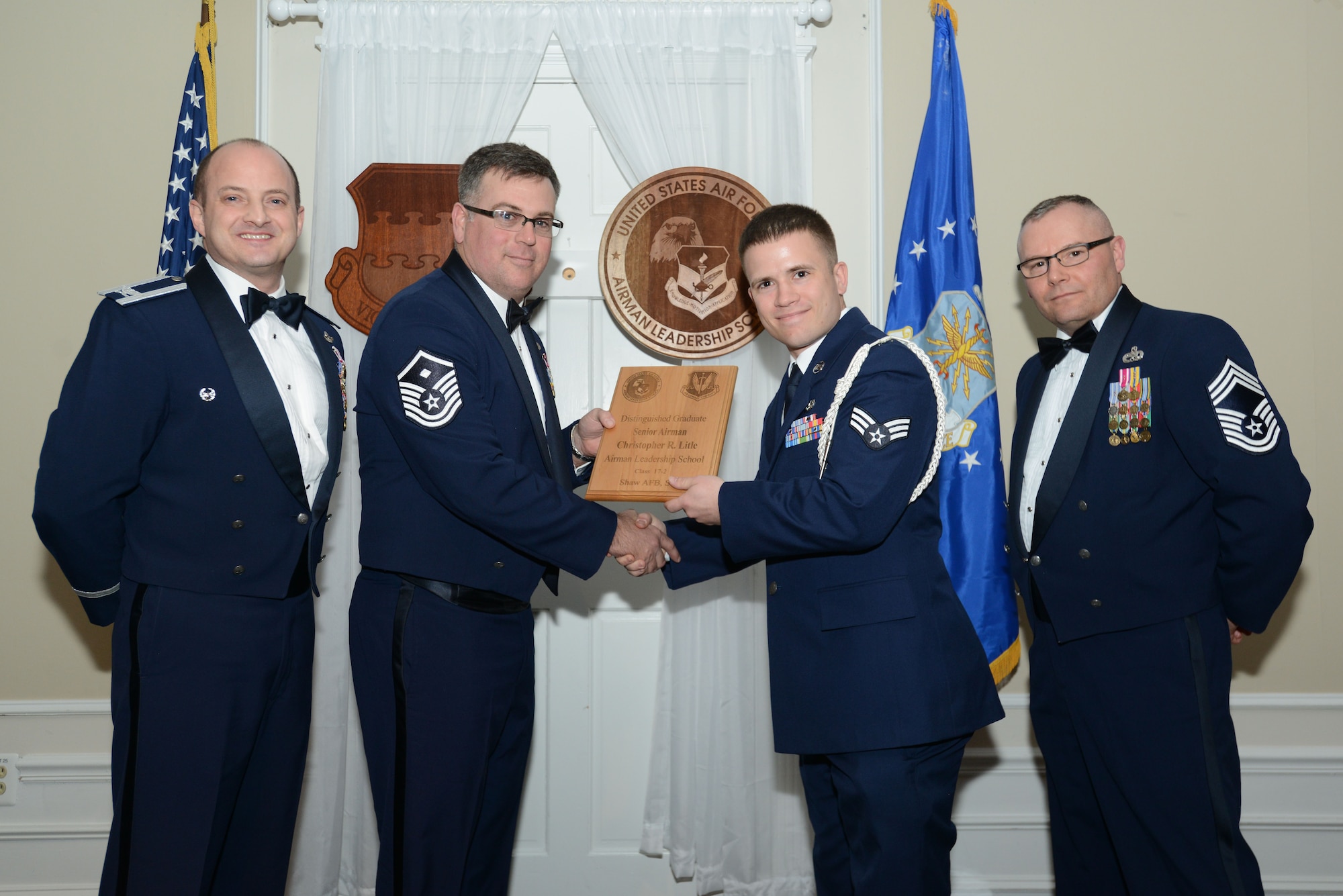 U.S. Air Force Senior Airman Christopher Litle, 20th Civil Engineer Squadron, receives a distinguished graduate award for the Senior Master Sgt. David B. Reid Airman Leadership School Class 17-2 from Master Sgt. Aaron Bunyea, 609th Air Communications Squadron first sergeant, at Shaw Air Force Base, S.C., Feb. 9, 2017. The distinguished graduate awards are given to the top 10 percent of the class for total point accumulation. (U.S. Air Force photo by Airman 1st Class Kelsey Tucker)