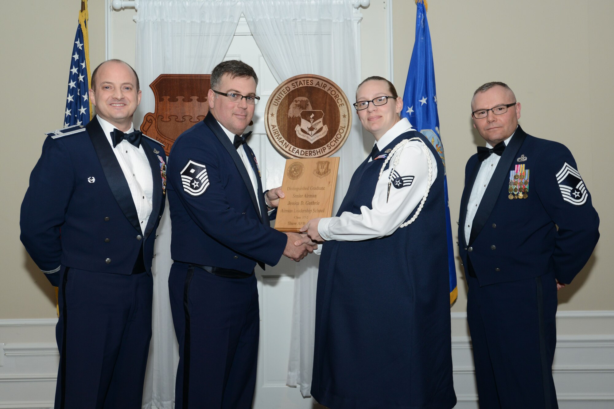 U.S. Air Force Senior Airman Jessica Guthrie, 3rd Intelligence Squadron, receives a distinguished graduate award for the Senior Master Sgt. David B. Reid Airman Leadership School Class 17-2 from Master Sgt. Aaron Bunyea, 609th Air Communications Squadron first sergeant, at Shaw Air Force Base, S.C., Feb. 9, 2017. The distinguished graduate awards are given to the top 10 percent of the class for total point accumulation. (U.S. Air Force photo by Airman 1st Class Kelsey Tucker)