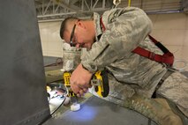 U.S. Air Force Master Sgt. Brent Proffitt, a sheet metal mechanic assigned to the 139th Maintenance Squadron, Missouri Air National Guard, sands down sheet metal on a C-130 Hercules aircraft at Rosecrans Air National Guard Base, St. Joseph, Mo., Feb. 8, 2017. Proffitt was assisting with aircraft maintenance that required the removal of the vertical stabilizer, or tail, of the aircraft. (U.S. Air National Guard photo by Master Sgt. Michael Crane)