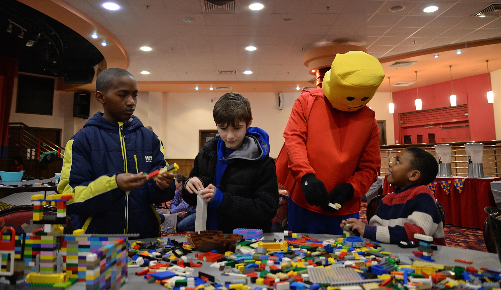 Children create structures with building blocks alongside a building block character during a “Young Engineer Camp” event Feb. 11, 2017, on RAF Mildenhall, England. The Airman and Family Readiness Center hosted the event for families of the Exceptional Family Member Program. (U.S. Air Force photo by Senior Airman Christine Halan) 