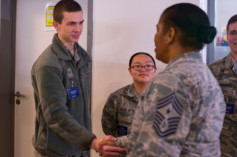 Chief Master Sgt. Shelina Frey, Air Mobility Command command chief, greets Airman 1st Class Dillon Warren, 726th Air Mobility Squadron passenger service agent, at the 726th AMS terminal during a visit at Spangdahlem Air Base, Germany, Feb. 13, 2017. Frey visited with AMC Airmen from various sections of the 726th AMS during her tour of Spangdahlem AB and recognize individual mobility Airmen for the dedication to the mission of the 726th AMS.  (U.S. Air Force photo by Senior Airman Dawn M. Weber