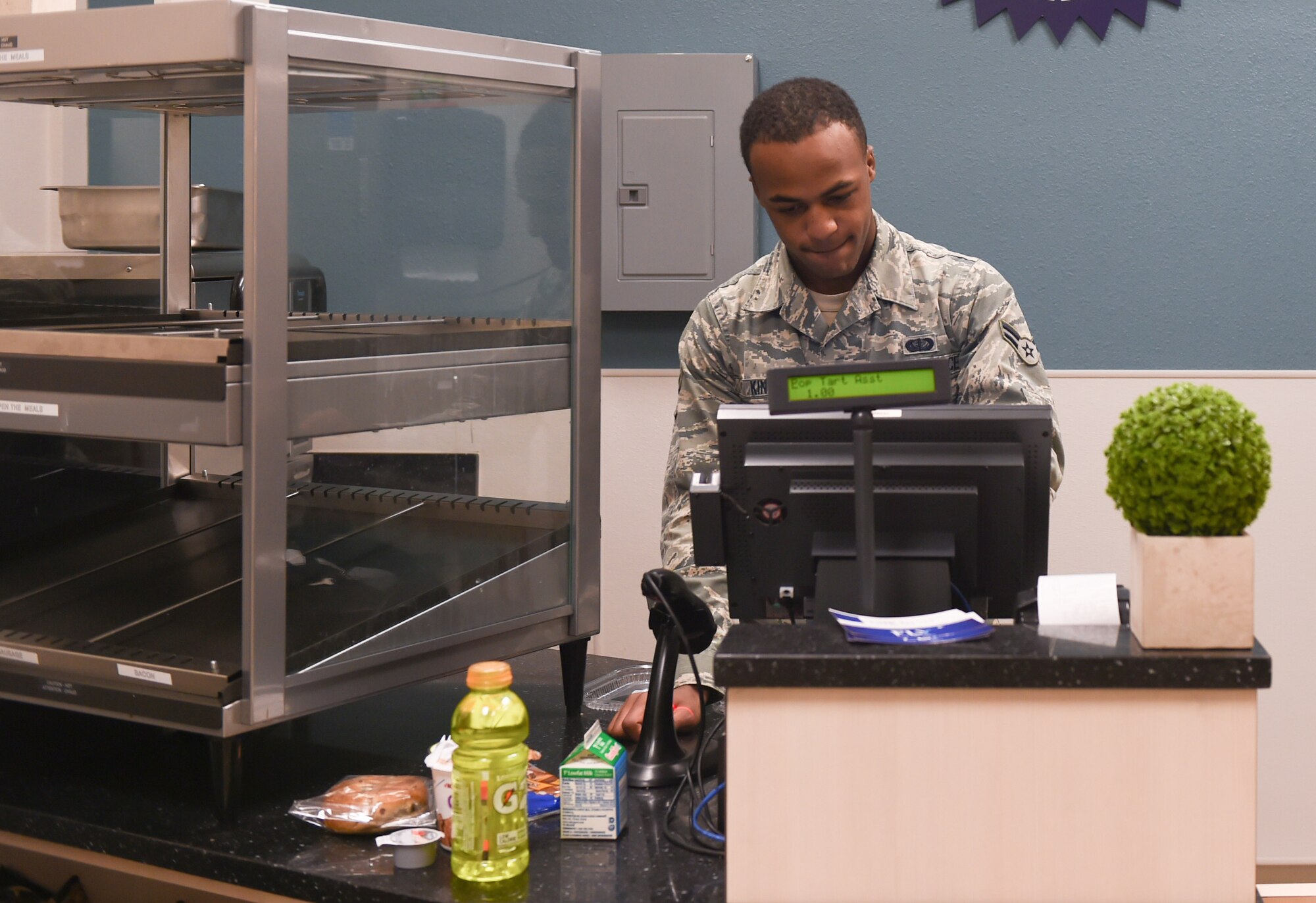 U.S. Air Force Airman 1st Class Malik King, 7th Force Support Squadron food service apprentice, processes a transaction at The Lift at Dyess Air Force Base, Texas, Feb. 8, 2017. The Lift is an extension of the Longhorn Dining Facility that provides hot meals and snacks to Airmen and aircrew on the flightline. Personnel can either pay with cash, debit or with their meal cards. (U.S. Air Force photo by Airman 1st Class Quay Drawdy)