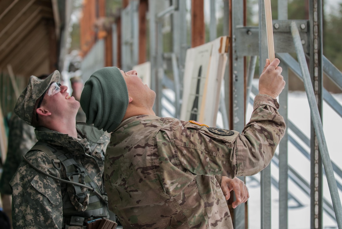 Spc. Christopher R. Williams, left watches on as Sgt. Demetrio Montoya indicates the number of rounds that hit a target at the known distance range portion of the 301st Maneuver Enhancement Brigade Best Warrior competition, at Joint Base Lewis-McChord, Wash. February 7, 2017. Best Warrior is an annual competition designed to test each soldier’s physical and mental fitness, proficiency in warrior tasks, resiliency, and their determination to be the best (U.S. Army Reserve Photo by Spc. Sean Harding/Released).