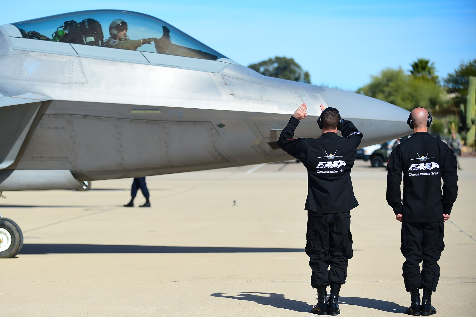 U.S. Air Force F-22 Raptor Demonstration Team crew chiefs, signal to an F-22 Raptor before take-off at the 2017 Heritage Flight Training and Certification Course at Davis-Monthan Air Force Base, Ariz., Feb. 9, 2017. The Demonstration Team assisted with more than 6 launches of the aircraft during the training and certification course. (U.S. Air Force photo by Senior Airman Kimberly Nagle) 