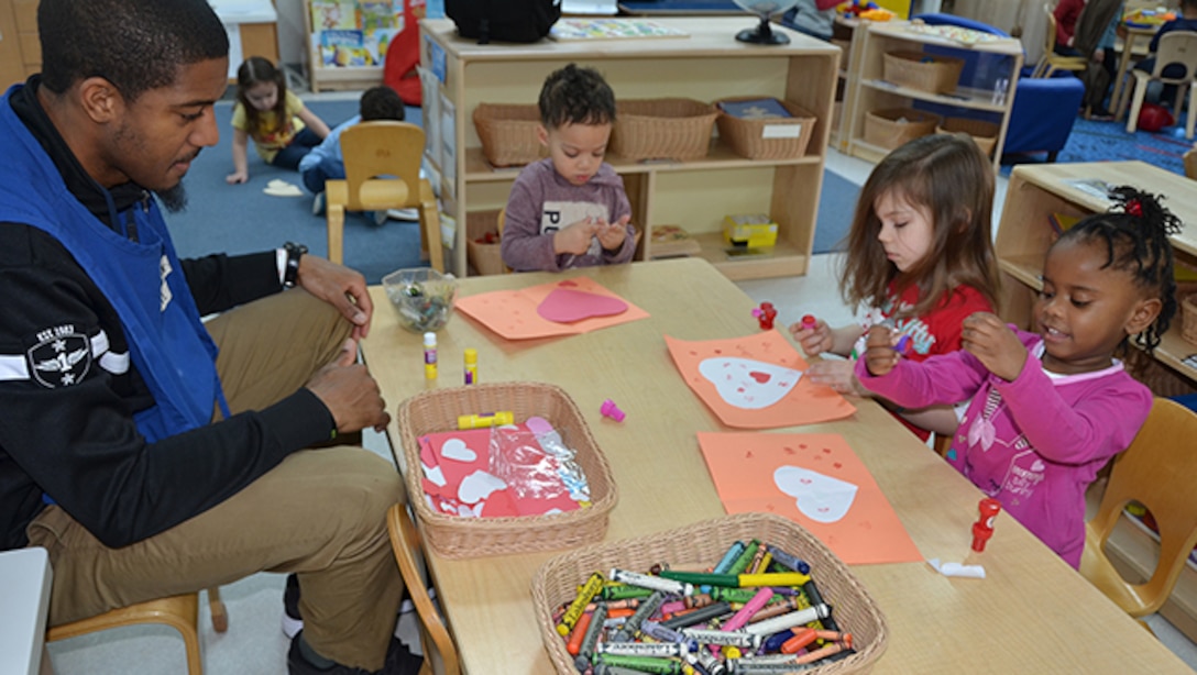 Derrhyl Duncan, a teacher in the four-year-old classroom of the Bettye Ackerman-Cobb Child Development Center, located on Defense Supply Center Richmond, Virginia, works with Eric Singleton, Kelly Bales, Kinsley Jackson (pink shirt) to make valentine cards Feb. 2, 2017 for veterans at the Hunter Holmes McGuire Veterans Medical Center as part of the VA’s annual Sault to Veterans.  
