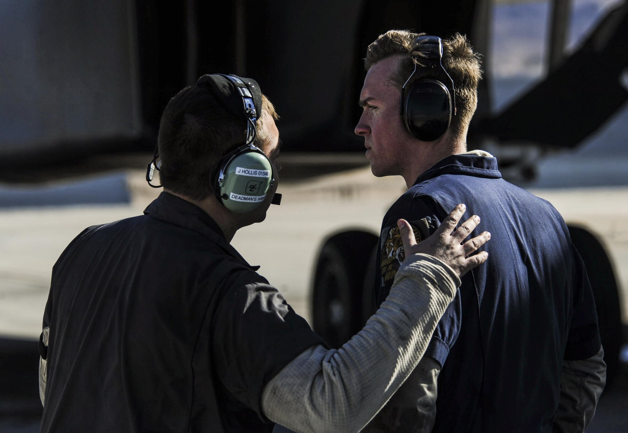 Staff Sgt. Justin Hollis and Senior Airman Jacob Widtmannheiser, crew chiefs assigned to the 28th Aircraft Maintenance Squadron, Ellsworth Air Force Base, S.D., talk as a B-1B Lancer prepares to takeoff during Red Flag 17-1 on Nellis Air Force Base, Nev., Jan. 27, 2017. All four branches of the U.S. military and air forces from allied nations participate in Red Flag in order to familiarize forces that will work together in future operations. (U.S. Air Force photo by Airman 1st Class Kevin Tanenbaum/Released)