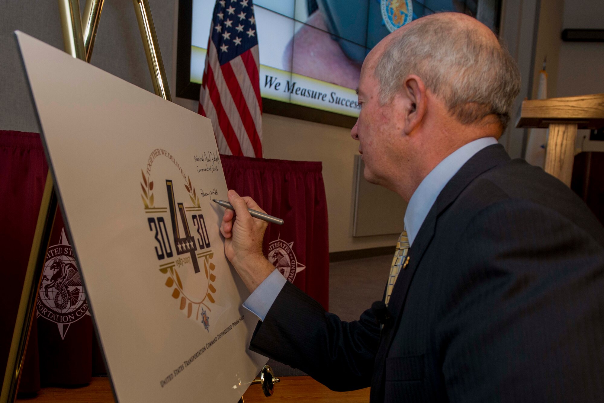 Retired Air Force Gen. Duncan McNabb signs his name on the 30-4-30 board during the Distinguished Speaker Series, an initiative to celebrate the command’s 30th anniversary in October 2017. McNabb was the USTRANCOM commander from 2008 – 2011. (U.S. Air Force photo/ Senior Airman Joshua Eikren)
