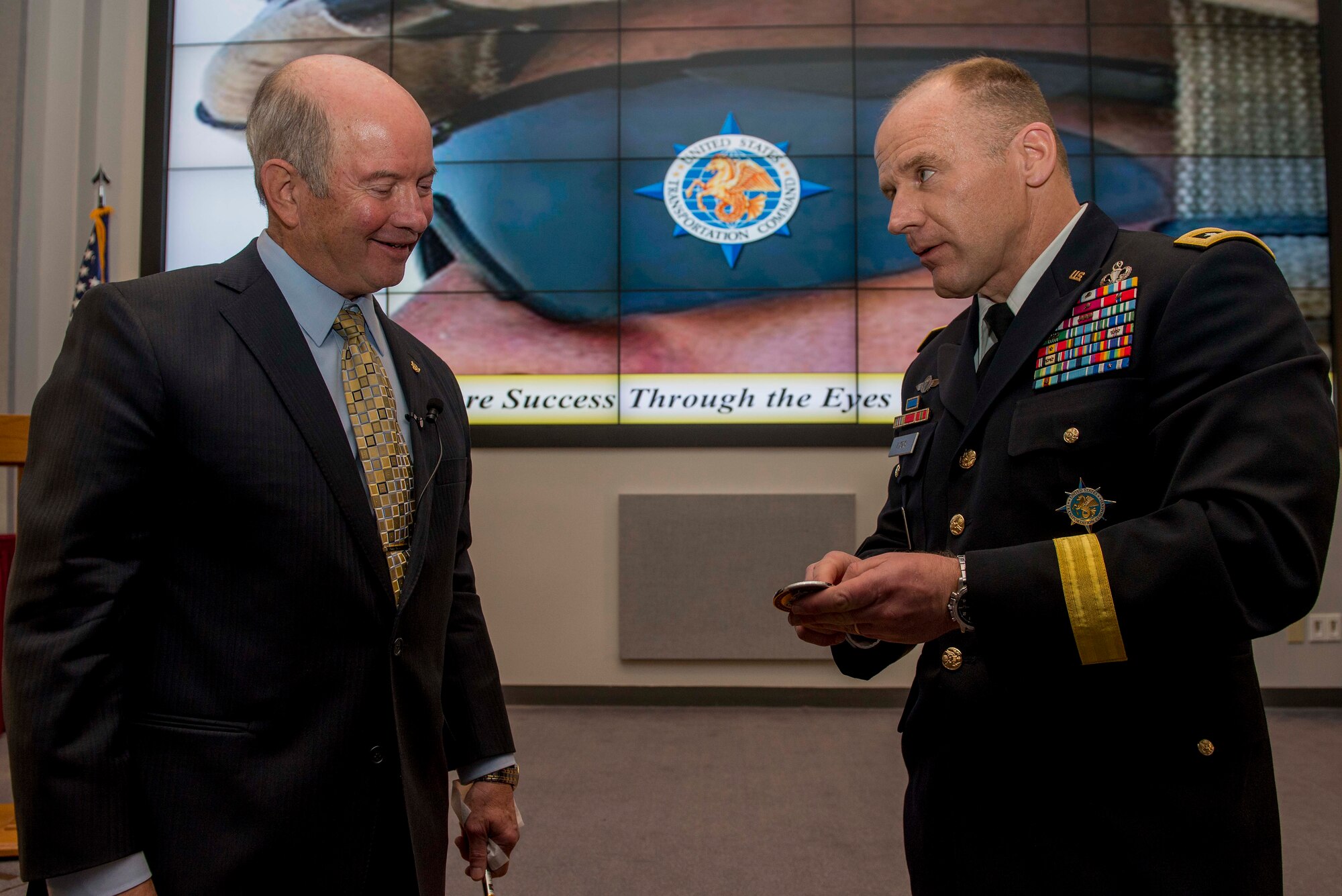 Army Lt. Gen. Stephen Lyons, U.S. Transportation Command deputy commander, presents the 30-4-30 USTRANSCOM coin to Retired Air Force Gen. Duncan McNabb during the Distinguished Speaker Series, an initiative to celebrate the command’s 30th anniversary in October 2017. McNabb was the USTRANCOM commander from 2008 – 2011. (U.S. Air Force photo/ Senior Airman Joshua Eikren)