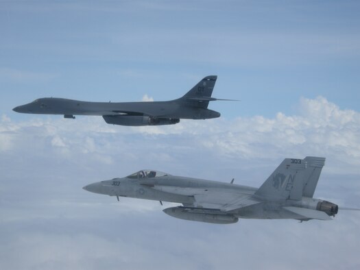 A B-1B Lancer from Andersen Air Force Base in Guam and a F/A-18E Super Hornet from the “Golden Dragons” of Strike Squadron (VFA) 192 fly over aircraft carrier USS Carl Vinson (CVN 70) as it transits the Philippine Sea. The B-1s are deployed in support of U.S. Pacific Command’s Continuous Bomber Presence mission. In place since 2004, the CBP missions are conducted by U.S. Air Force bombers such as the B-1, B-52 Stratofortress and B-2 Spirit in order to provide non-stop stability and security in the Indo-Asia-Pacific region. The Carl Vinson Strike Group is on a regularly scheduled Western Pacific deployment as part of the U.S. Pacific Fleet-led initiative to extend the command and control functions of U.S. 3rd Fleet. U.S. Navy aircraft carrier strike groups have patrolled the Indo-Asia-Pacific regularly and routinely for more than 70 years. (U.S. Navy photo by Lt. Robert Nordlund)