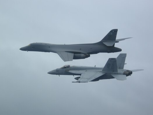 A B-1B Lancer from Andersen Air Force Base in Guam and a F/A-18E Super Hornet from the “Golden Dragons” of Strike Squadron (VFA) 192 fly over aircraft carrier USS Carl Vinson (CVN 70) as it transits the Philippine Sea. The B-1s are deployed in support of U.S. Pacific Command’s Continuous Bomber Presence mission. In place since 2004, the CBP missions are conducted by U.S. Air Force bombers such as the B-1, B-52 Stratofortress and B-2 Spirit in order to provide non-stop stability and security in the Indo-Asia-Pacific region. The Carl Vinson Strike Group is on a regularly scheduled Western Pacific deployment as part of the U.S. Pacific Fleet-led initiative to extend the command and control functions of U.S. 3rd Fleet. U.S. Navy aircraft carrier strike groups have patrolled the Indo-Asia-Pacific regularly and routinely for more than 70 years. (U.S. Navy photo by Lt. Robert Nordlund)