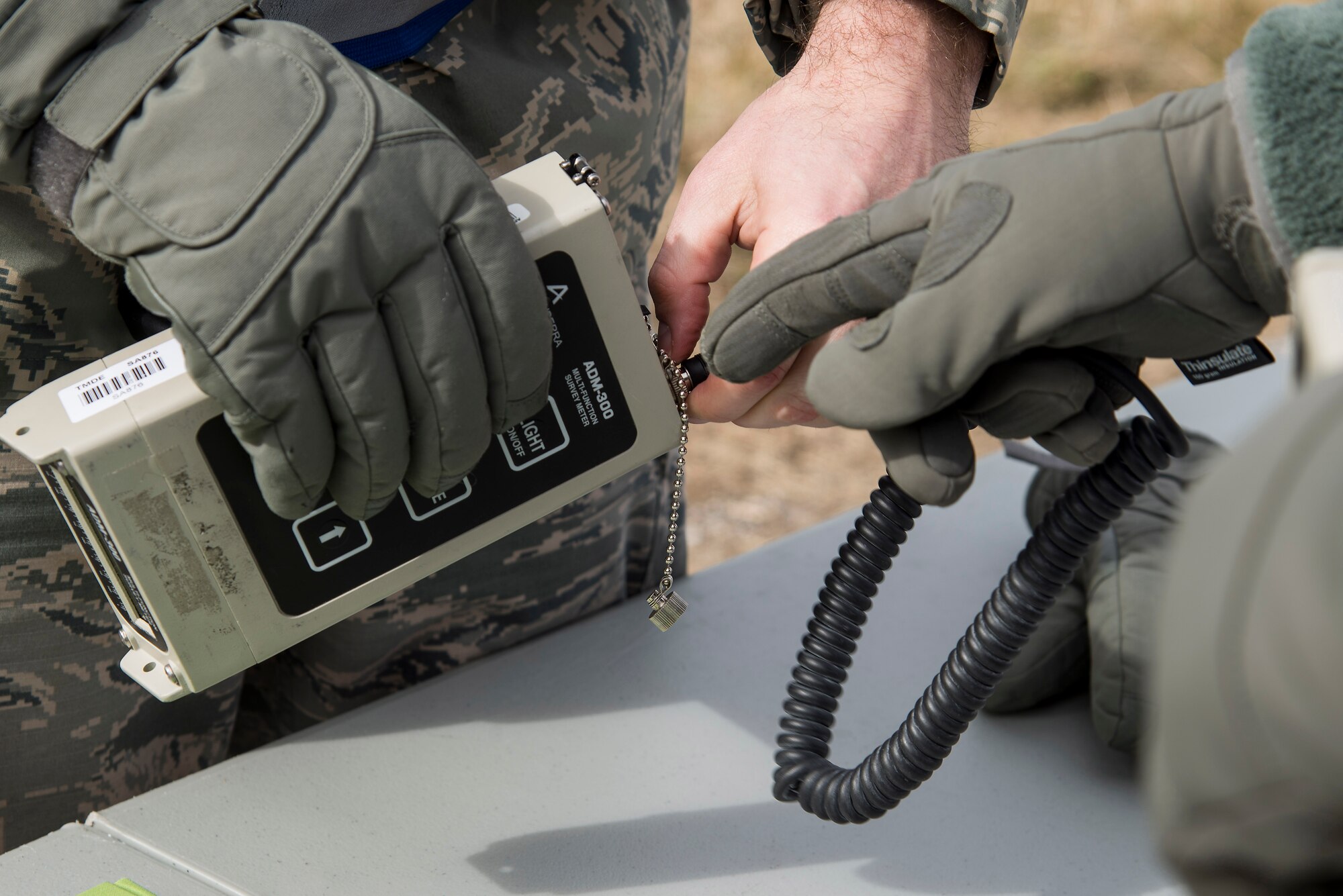 Members of Emergency Management prepare to attach a probe to the AMD-300, a radiation detection device designed to detect, measure, and digitally display levels of gamma radiation during an exercise at Scott Air Force Base, Illinois, Feb. 9, 2016. This was an exercise to test Scott's response to an explosion with potential chemical, biological, radiological and nuclear contamination. (U.S. Air Force photo by Airman 1st Class Daniel Garcia)