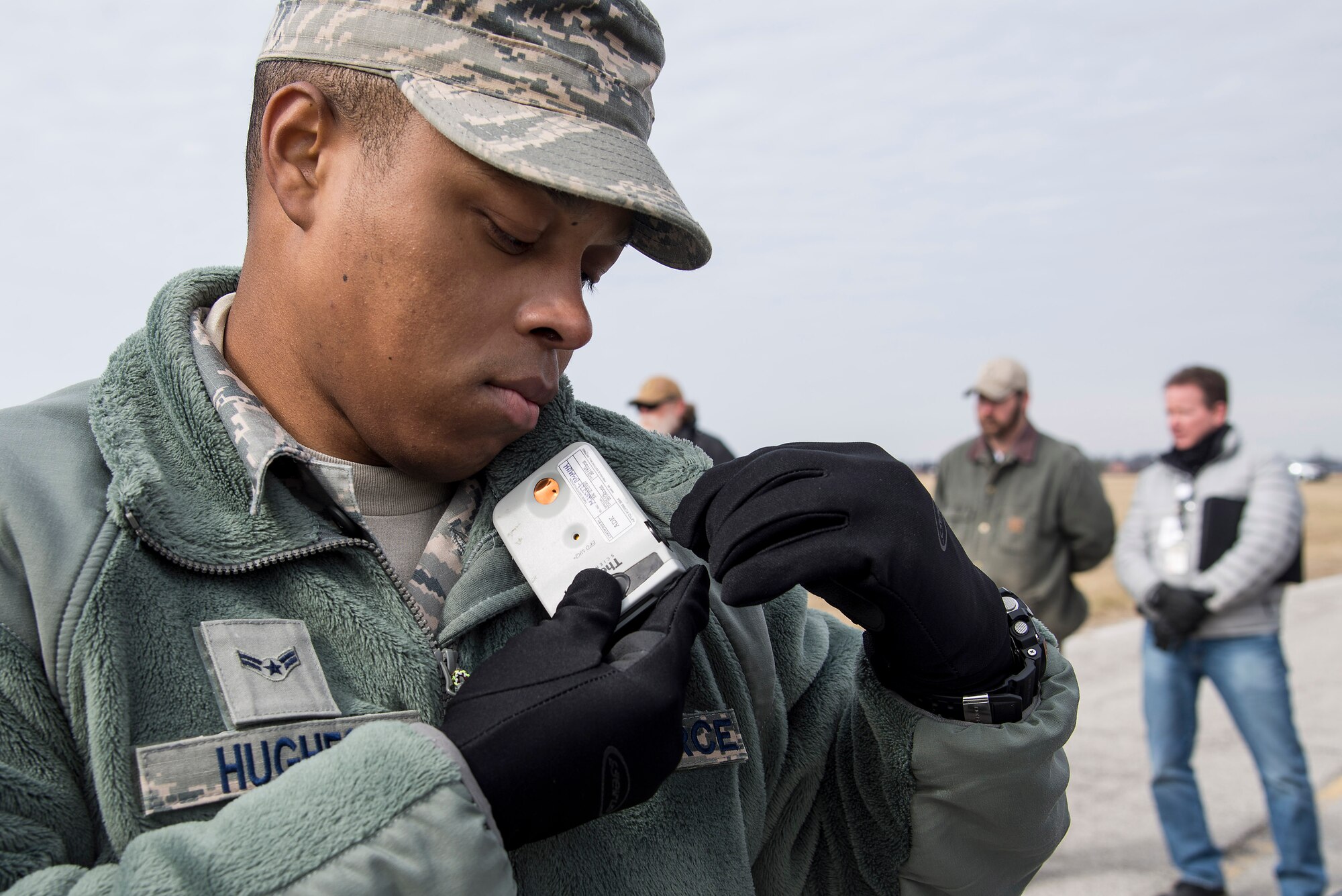 Airman 1st Class Keyman Hughes, 375th Aerospace Medicine Squadron bioenvironmental engineering technician, attaches an electronic personal dosimeter to his fleece to detech levels of beta and gamma radiation during an exercise at Scott Air Force Base, Illinois, Feb. 9, 2016.  This was an exercise to test Scott's response to an explosion with potential chemical, biological, radiological and nuclear contamination. (U.S. Air Force photo by Airman 1st Class Daniel Garcia)