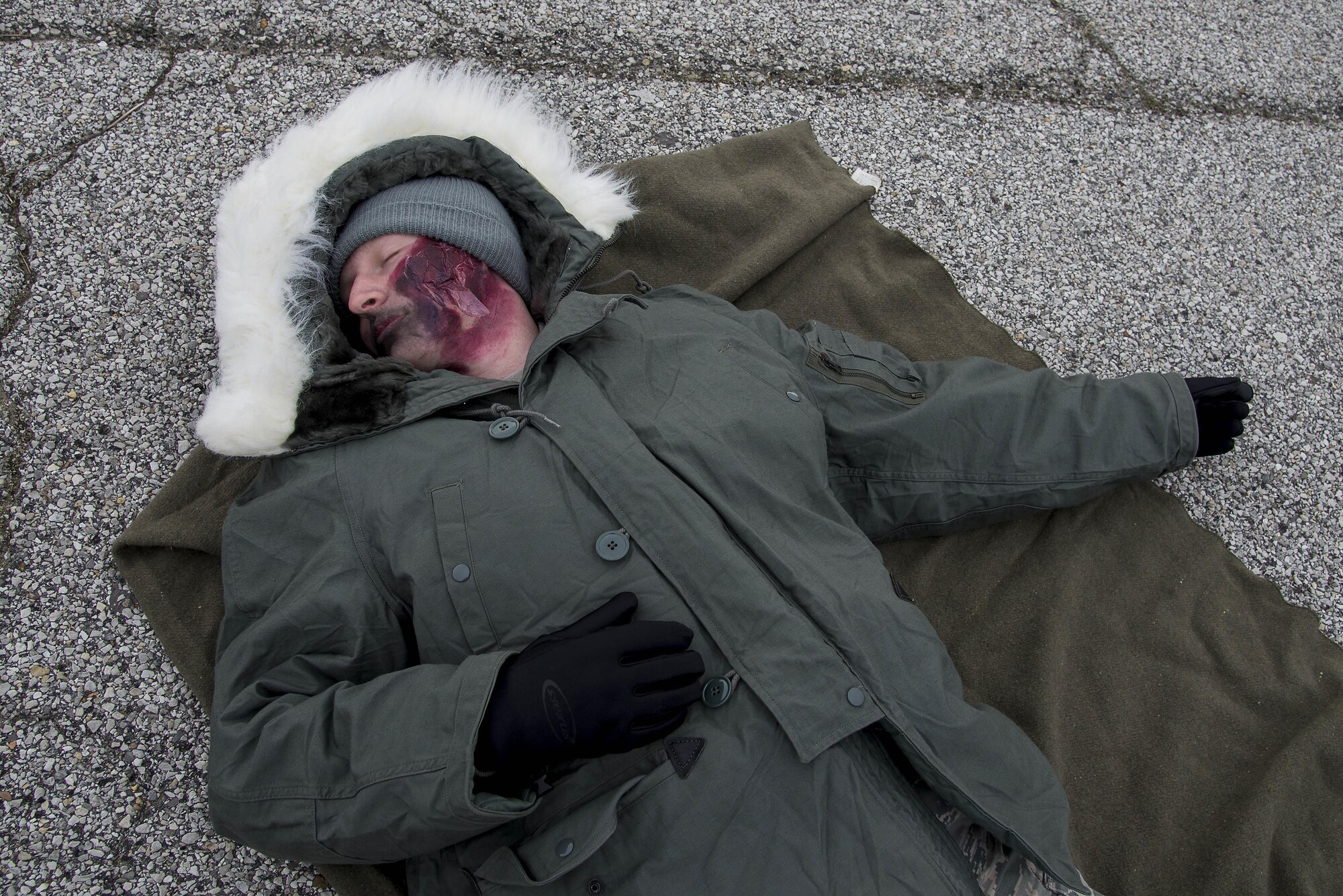 Airman 1st Class Austin Felts, 15th Operational Weather Squadron weather forecaster, acts as a victim of an explosion during an exercise at Scott Air Force Base, Illinois, Feb. 9, 2016. This was an exercise to test Scott's response to an explosion with potential chemical, biological, radiological and nuclear contamination. (U.S. Air Force photo by Airman 1st Class Daniel Garcia)