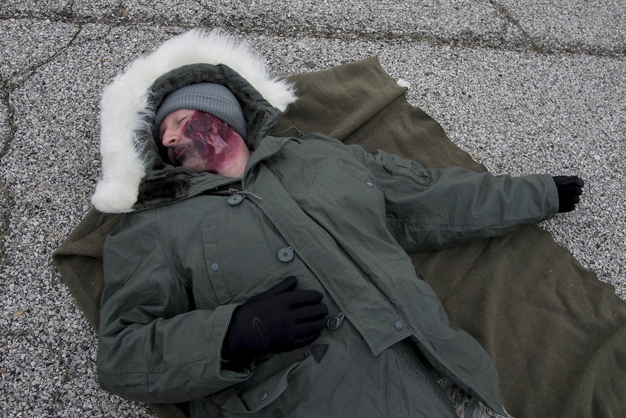 Airman 1st Class Austin Felts, 15th Operational Weather Squadron weather forecaster, acts as a victim of an explosion during an exercise at Scott Air Force Base, Illinois, Feb. 9, 2016. This was an exercise to test Scott's response to an explosion with potential chemical, biological, radiological and nuclear contamination. (U.S. Air Force photo by Airman 1st Class Daniel Garcia)