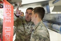 Specialist Gene Osborne, a 734th Ordnance Company Explosive Ordnance Disposal technician at Fort Bliss, Texas, points out a key function on an F-16 Fighting Falcon to Senior Airman Benjamin Vetter, a 49th Civil Engineer Squadron EOD technician at Holloman Air Force Base, N.M. Feb. 14, 2017. The 49th EOD team work with the 734th EOD team on training tasks in order to provide them with more hands-on experience with the aircrafts. (U.S. Air Force photo by Airman Ilyana A. Escalona)