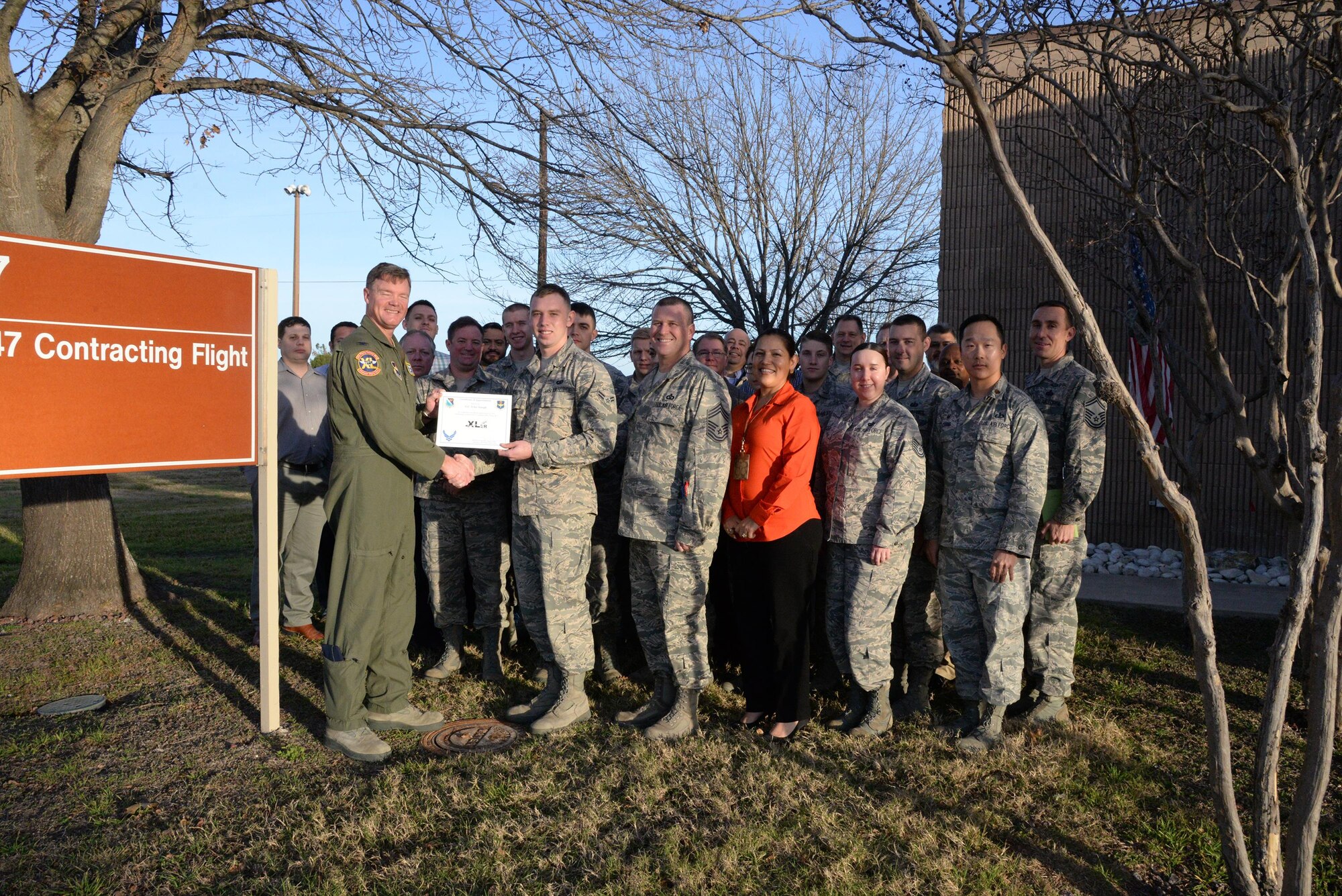 Airman 1st Class Tyler Joseph, 47th Contracting Flight contract specialist (front center), accepts the “XLer of the Week” award from Col. Thomas Shank, 47th Flying Training Wing commander (front left), and Chief Master Sgt. George Richey, 47th FTW command chief (front right), on Laughlin Air Force Base, Texas, Feb. 8, 2017. The XLer is a weekly award chosen by wing leadership and is presented to those who consistently make outstanding contributions to their unit and Laughlin. (U.S. Air Force photo/Airman 1st Class Daniel Hambor)