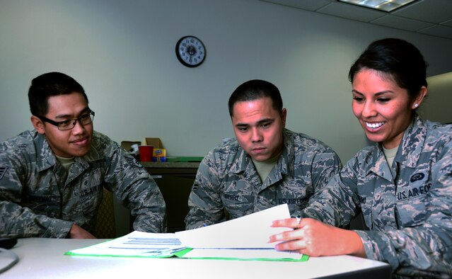 Staff Sgt. Saecho Kao Seng, a 349th Force Support Squadron personnel specialist, aids Airmen 1st Class Justin Ferry and Samantha Bambino, of the 60th Force Support Squadron, in commissioning packages for Airmen assigned to the 349th Air Mobility Wing at Travis Air Force Base, Calif., Feb. 15, 2017. The 60th and 349th FSS units have been working together to become a seamless unit and Total Force Support Squadron in March. (U.S. Air Force photo/Staff Sgt. Daniel Phelps)