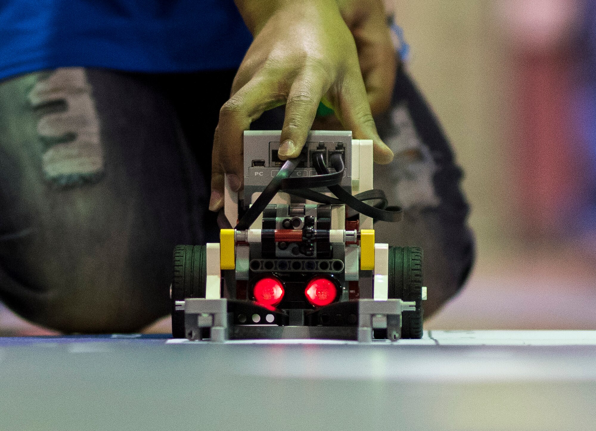 A member of the Barksdale Air Force Base Youth Center robotics team places his team’s robot on a practice mat during the Regional Autonomous Robotics Circuit in Bossier City, La., Feb. 11, 2017. The team’s robot is required to complete a variety of tasks. The challenges require teams to learn about energy resources while exploring a newly-discovered, uncharted island with their robots. (U.S. Air Force photo/Senior Airman Damon Kasberg)