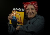 Margaret “Peggy” Wills, B-24 electrician during World War II, holds a recruitment poster at Minot Air Force Base, Feb. 9, 2017. Wills was a Rosie the Riveter at Holman Field in St. Paul, Minn. (U.S. Air Force photo/Senior Airman Apryl Hall)