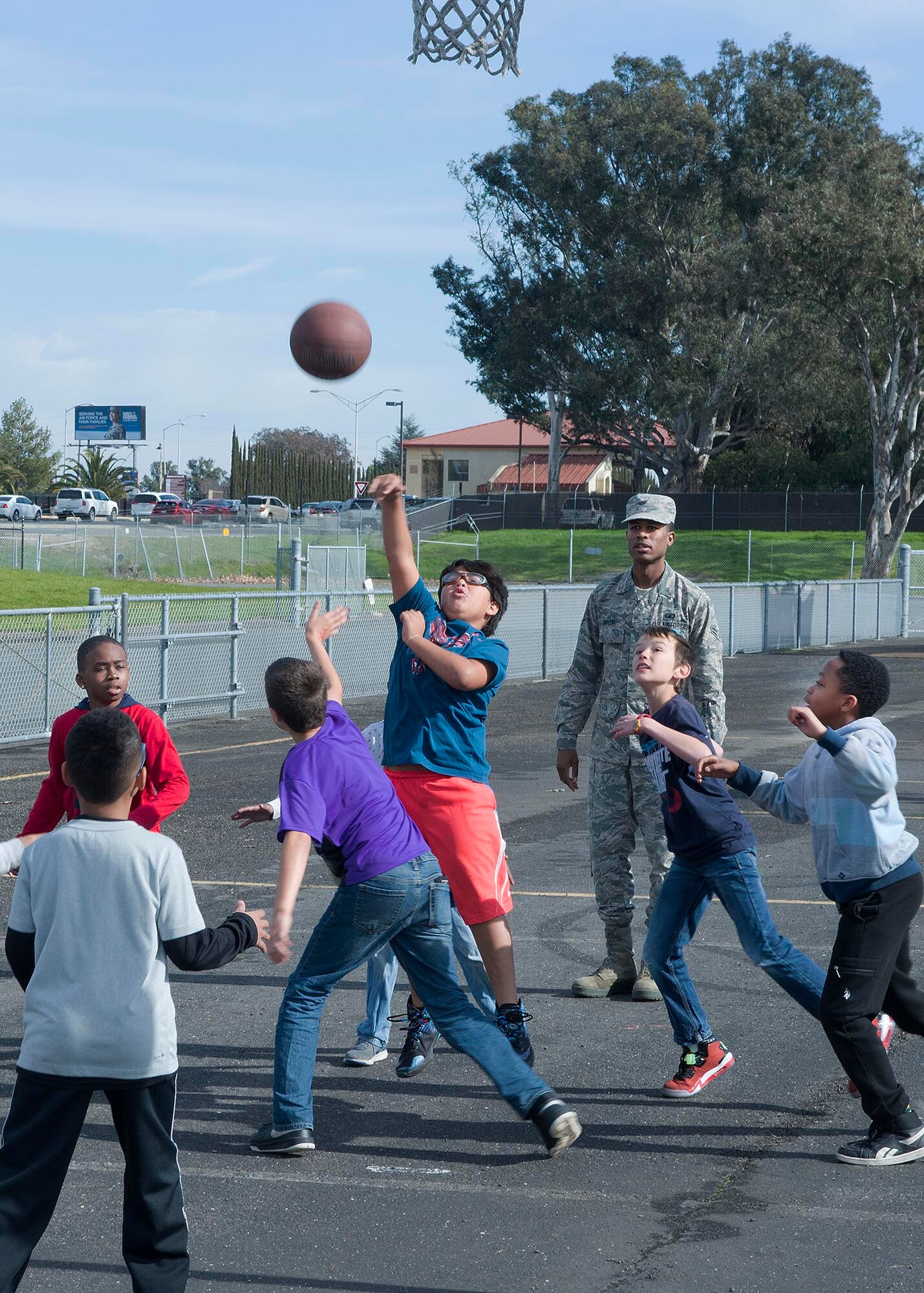 Airman 1st Class Adam Taylor, 60th Contracting Squadron, supervises children playing a basketball game at Travis Elementary School at Travis Air Force Base, Calif., Feb. 7, 2017. Taylor is a regular volunteer at the school as a yard monitor. (U.S. Air Force  photo/T.C. Perkins Jr.)
