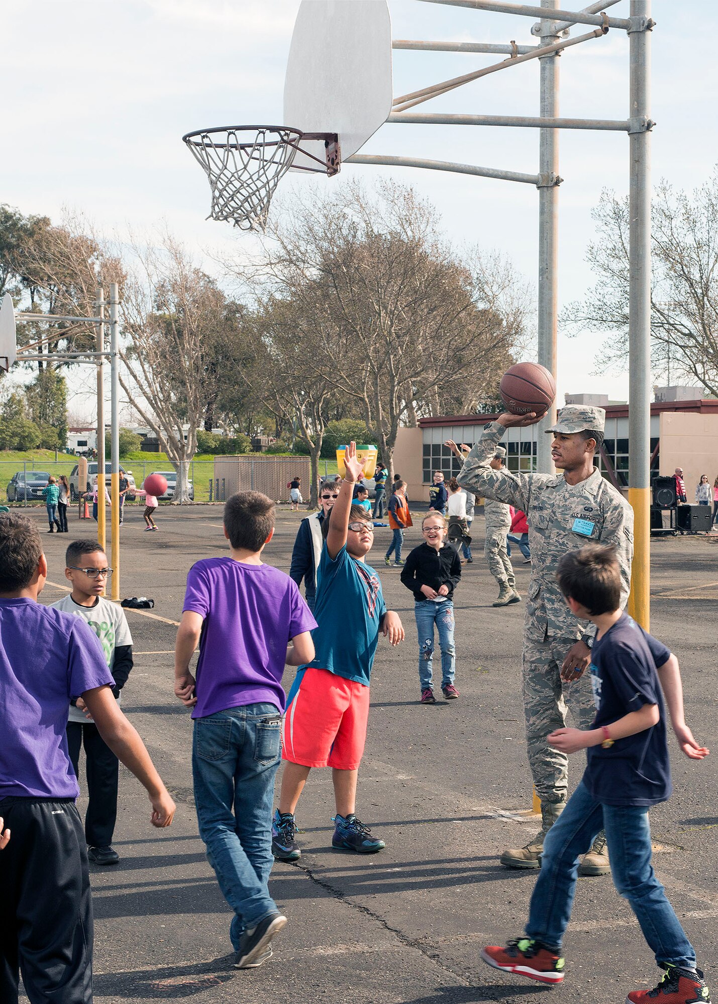 Airman 1st Class Adam Taylor, 60th Contracting Squadron, supervises children playing a basketball game at Travis Elementary School at Travis Air Force Base, Calif., Feb. 7, 2017. Taylor is a regular volunteer at the school as a yard monitor. (U.S. Air Force  photo/T.C. Perkins Jr.)