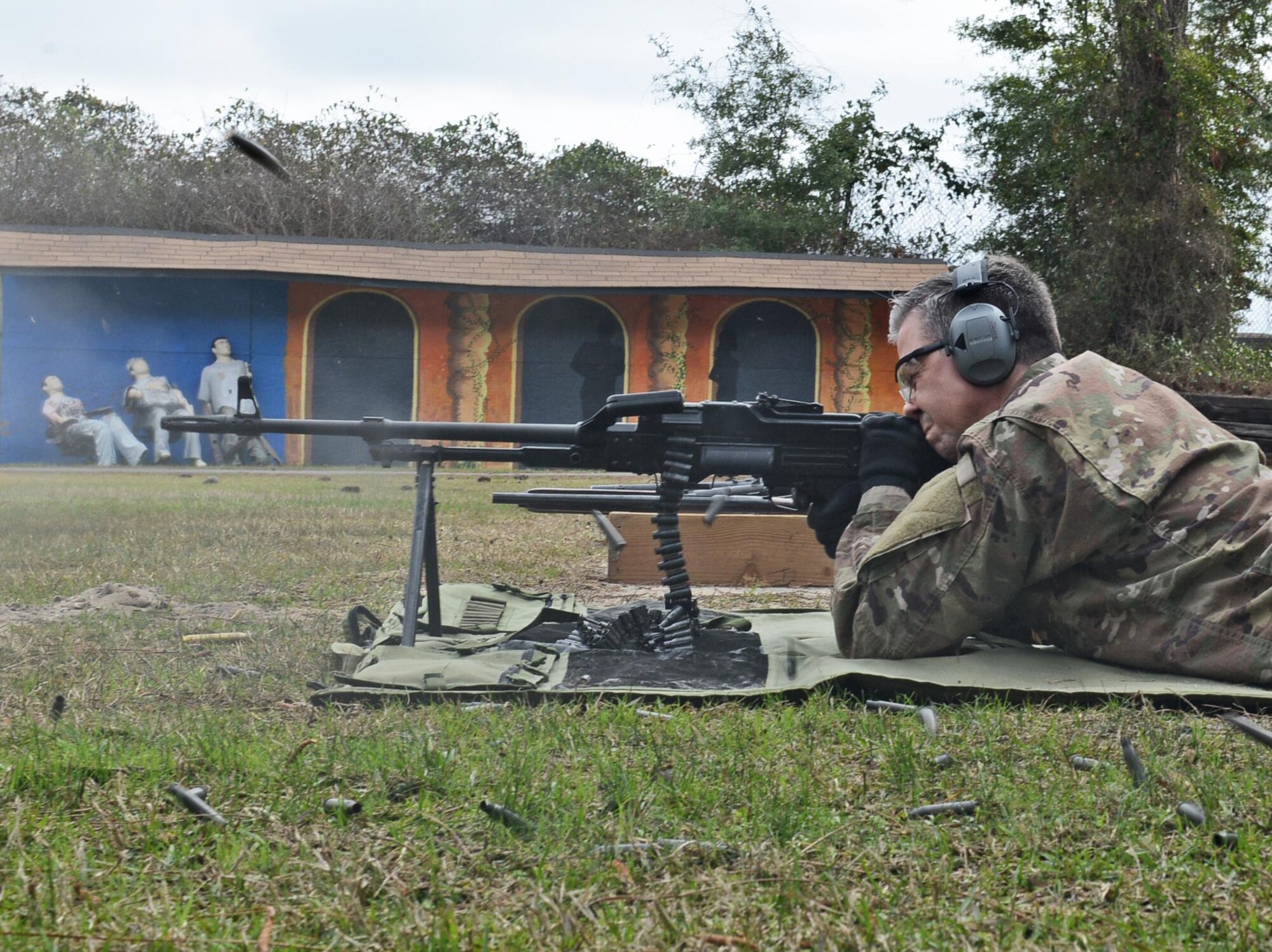 A casing flies from a Russian PKM Machine Gun as Capt. Daniel Jasper, United States Air Force Special Operations School course director, fires at a target on Hurlburt Field, Fla., Feb. 15, 2017. Jasper demonstrated the weapon’s capability to about 15 people going through the Special Operations Command Civilian Development program. (U.S. Air Force photo/Staff Sgt. Melanie Holochwost)